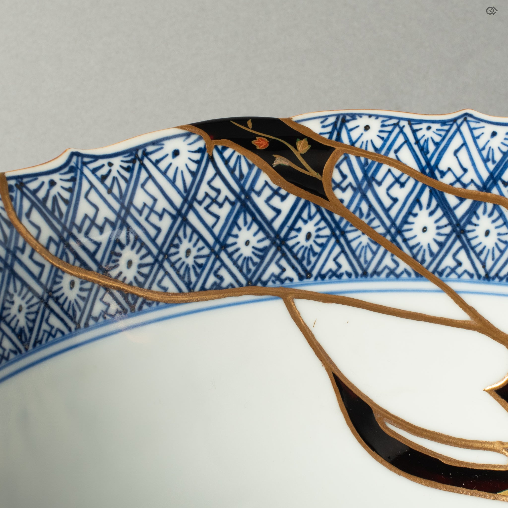 A detailed view of the rare Yobitsugi technique, where a fragment from another historic ceramic has been seamlessly integrated into the repair, showcasing the master's profound knowledge and skill.