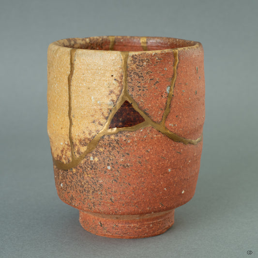 The rustic form of a Shigaraki ware tea cup, its earthy texture beautifully complemented by both 24k gold Kintsugi and the sophisticated Nashiji 'pear-skin' lacquer technique.