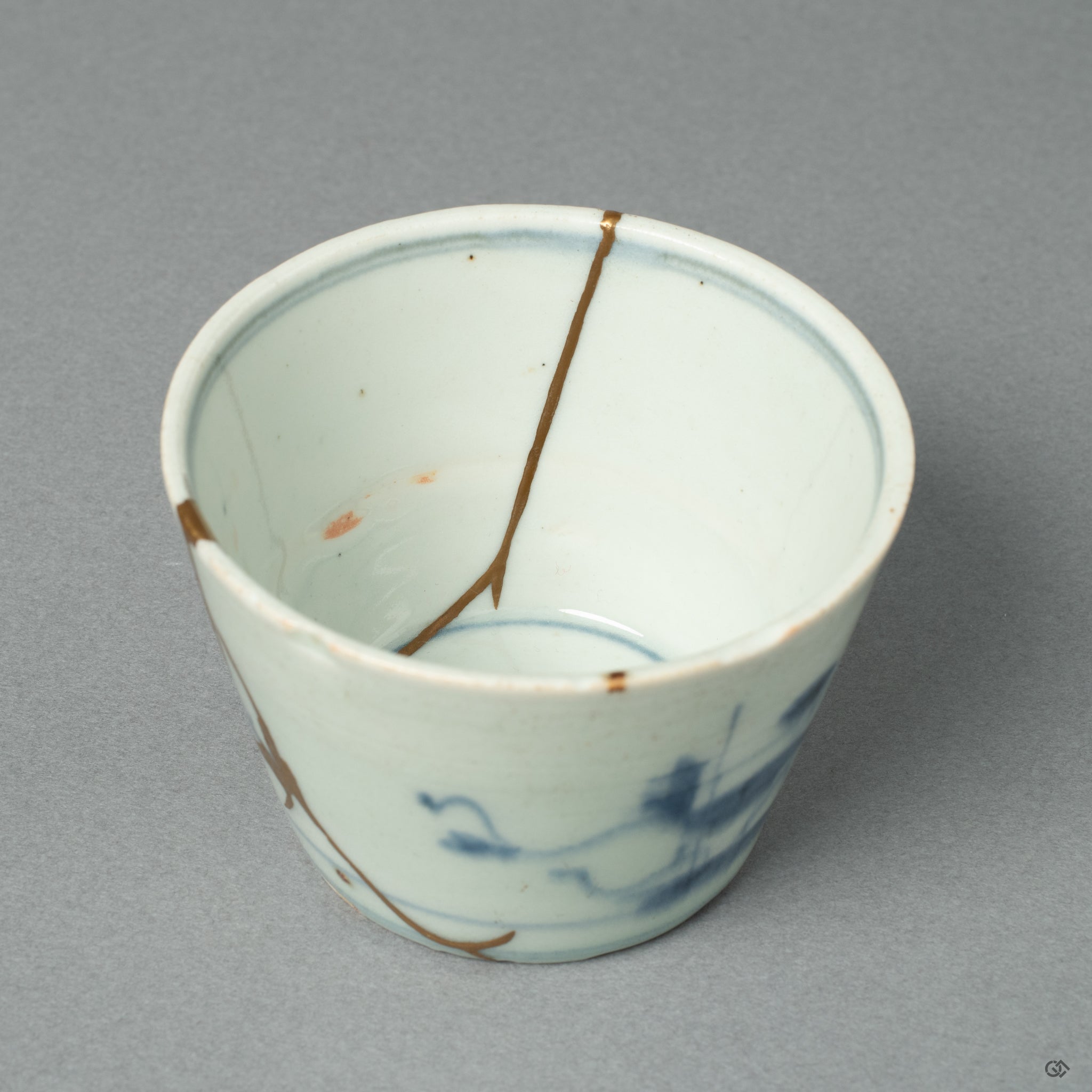 This macro view shows a luminous 24k gold seam, a line of light that brings a new chapter to this Edo-period ochoko's long and storied life.