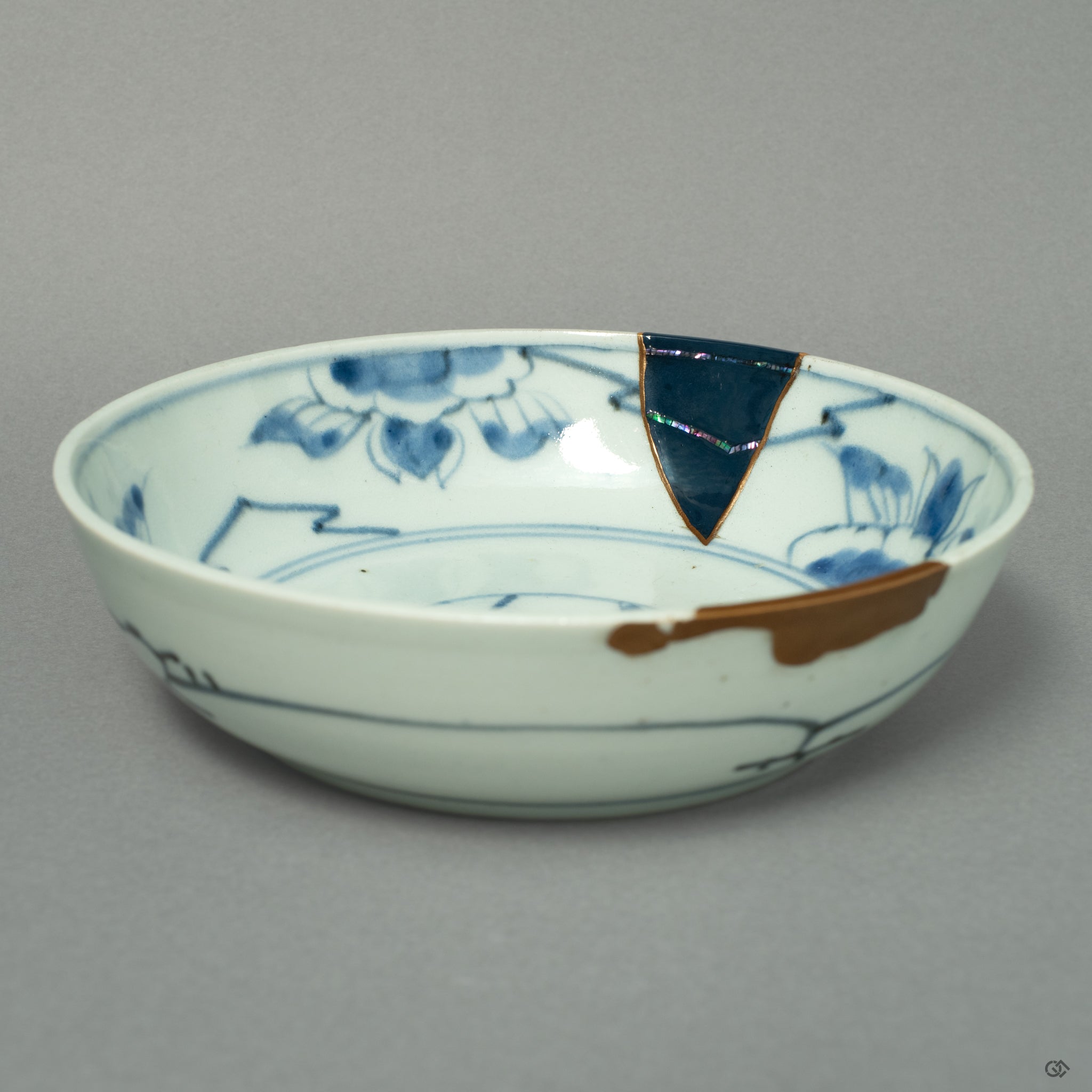 A front view of a Ko-Imari ware bowl, where lines of 24k gold and iridescent Raden inlay create a celestial dialogue on the porcelain canvas.