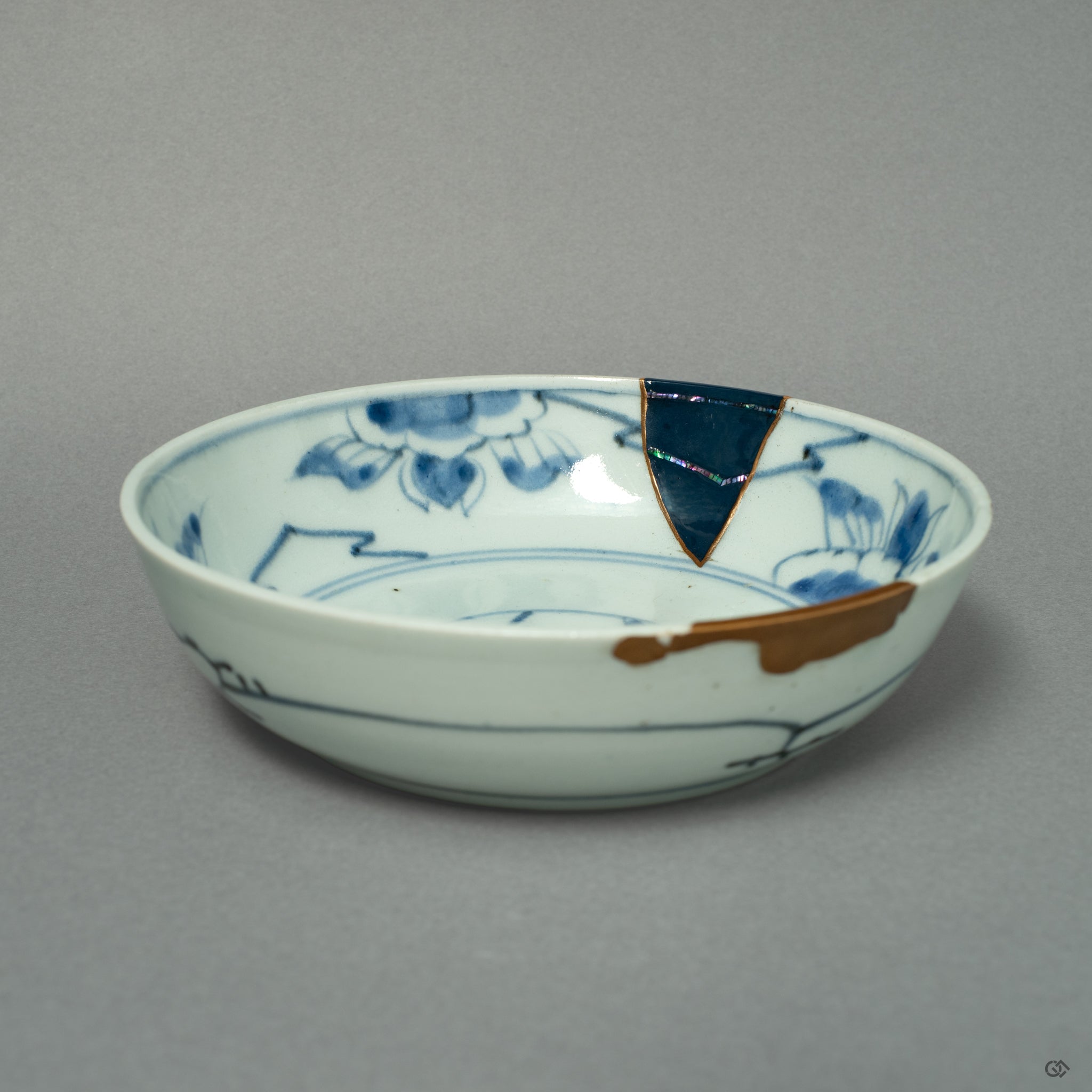 A front view of a Ko-Imari ware bowl, where lines of 24k gold and iridescent Raden inlay create a celestial dialogue on the porcelain canvas.