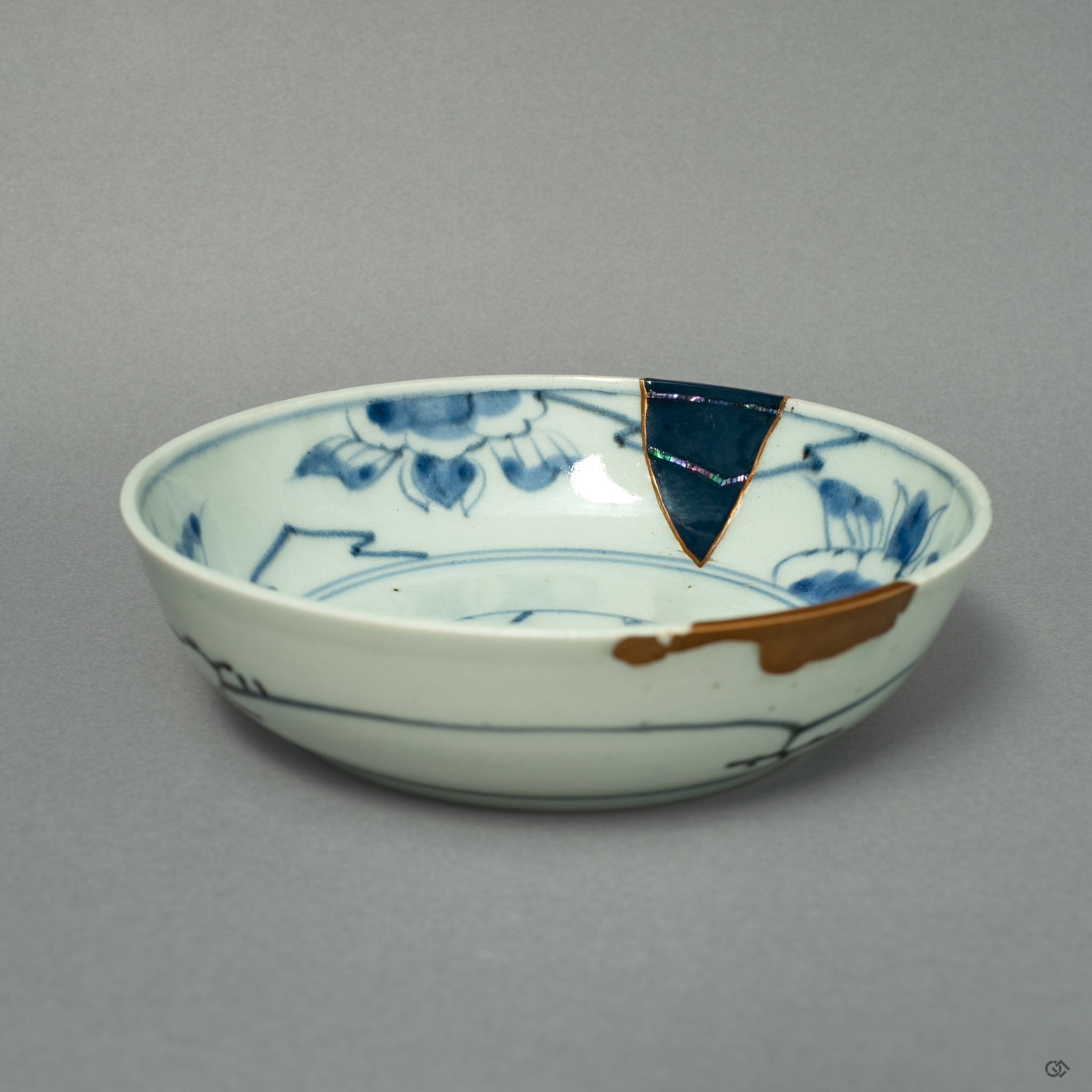 A front view of a Ko-Imari ware bowl, where lines of 24k gold and iridescent Raden inlay create a celestial dialogue on the porcelain canvas.