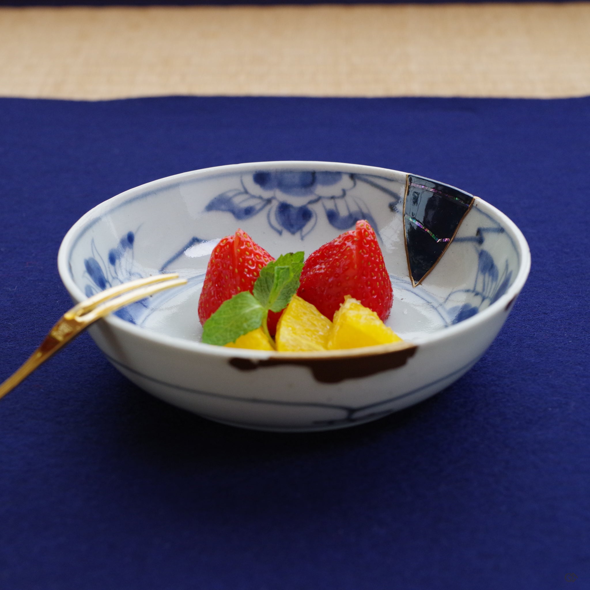 The Ko-Imari bowl held in a moment of quiet contemplation, its artistic repair integrated into the simple grace of a daily ritual.