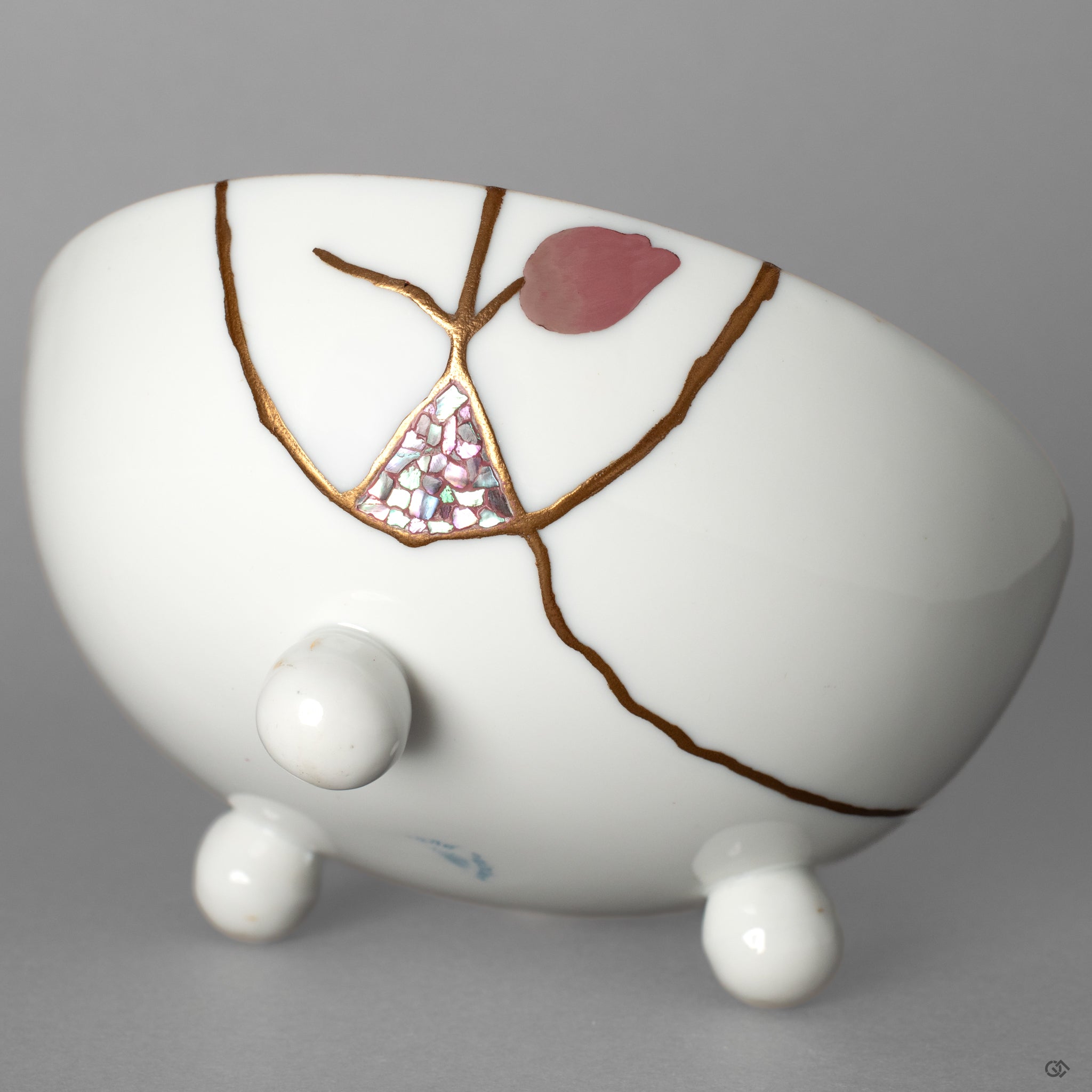 A macro view of the urushi-e and raden inlay on the porcelain. There is a 'story in every seam, a narrative of rebirth told in urushi lacquer and gold.