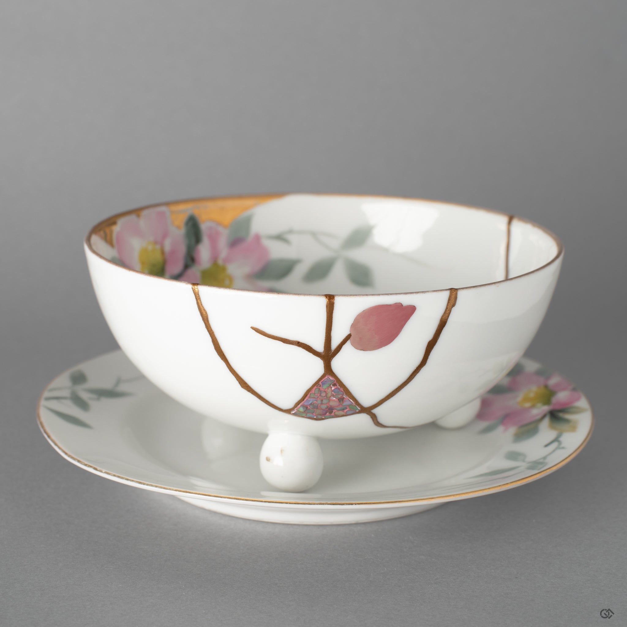 Front view of an Early Noritake cup and saucer restored with 24K gold, urushi-e, and raden, beginning a new story to tell for this heirloom.