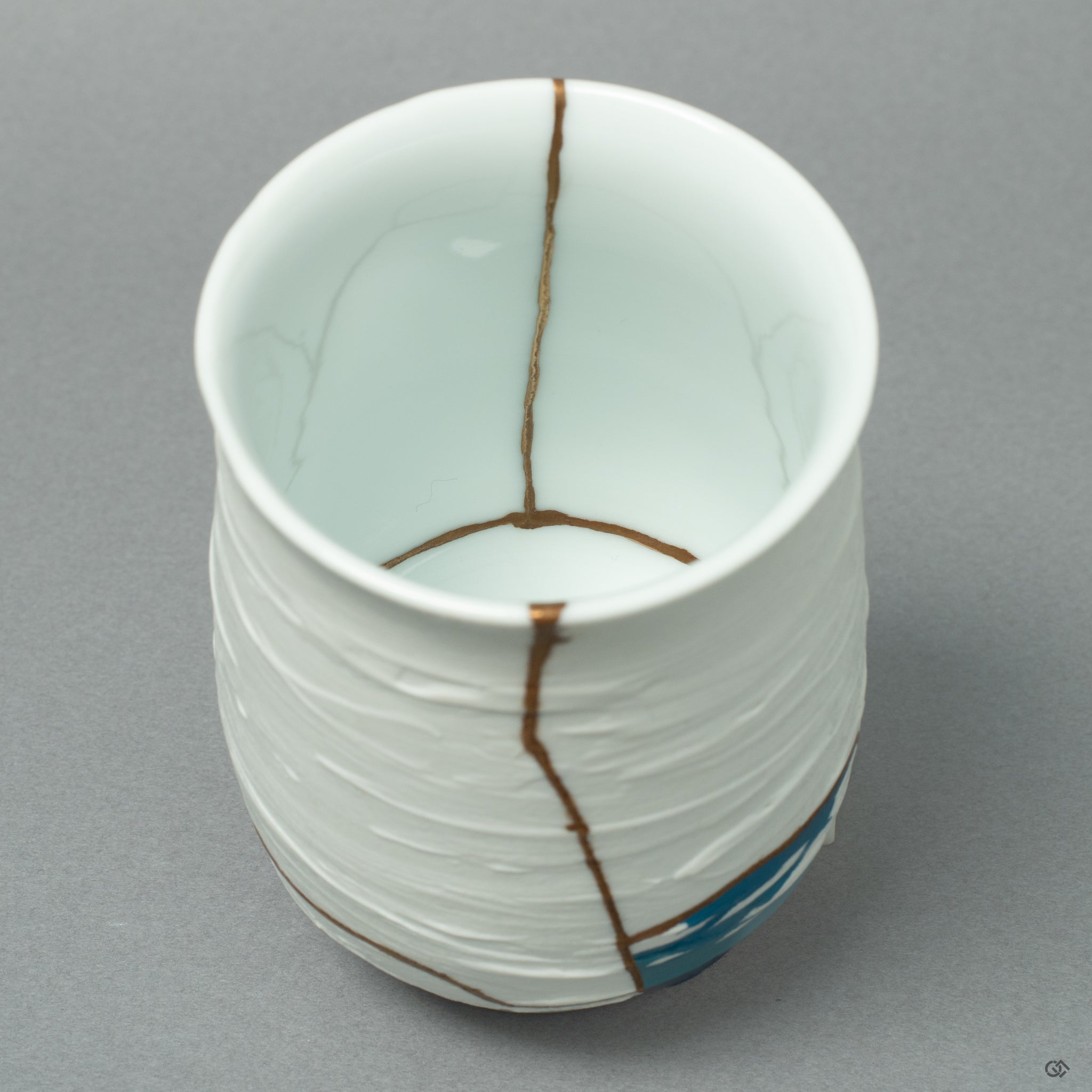 An intimate detail capturing the brilliant texture of a 24k gold line, a testament to the artisan's skill in transforming a fracture into fine art.