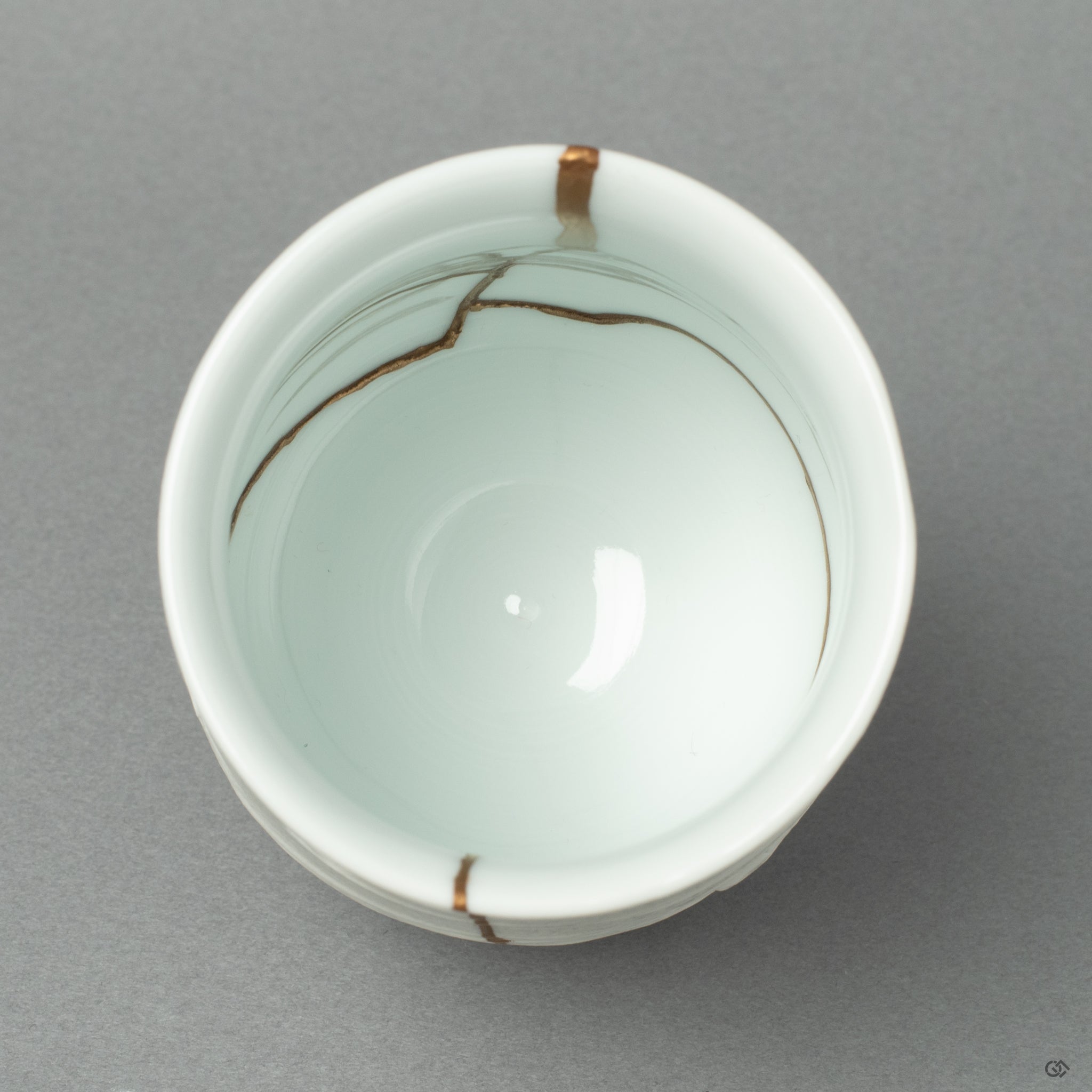 A top-down view into the cup, revealing the pristine white Nabeshima porcelain that serves as the sky above the blue Urushi-e horizon.