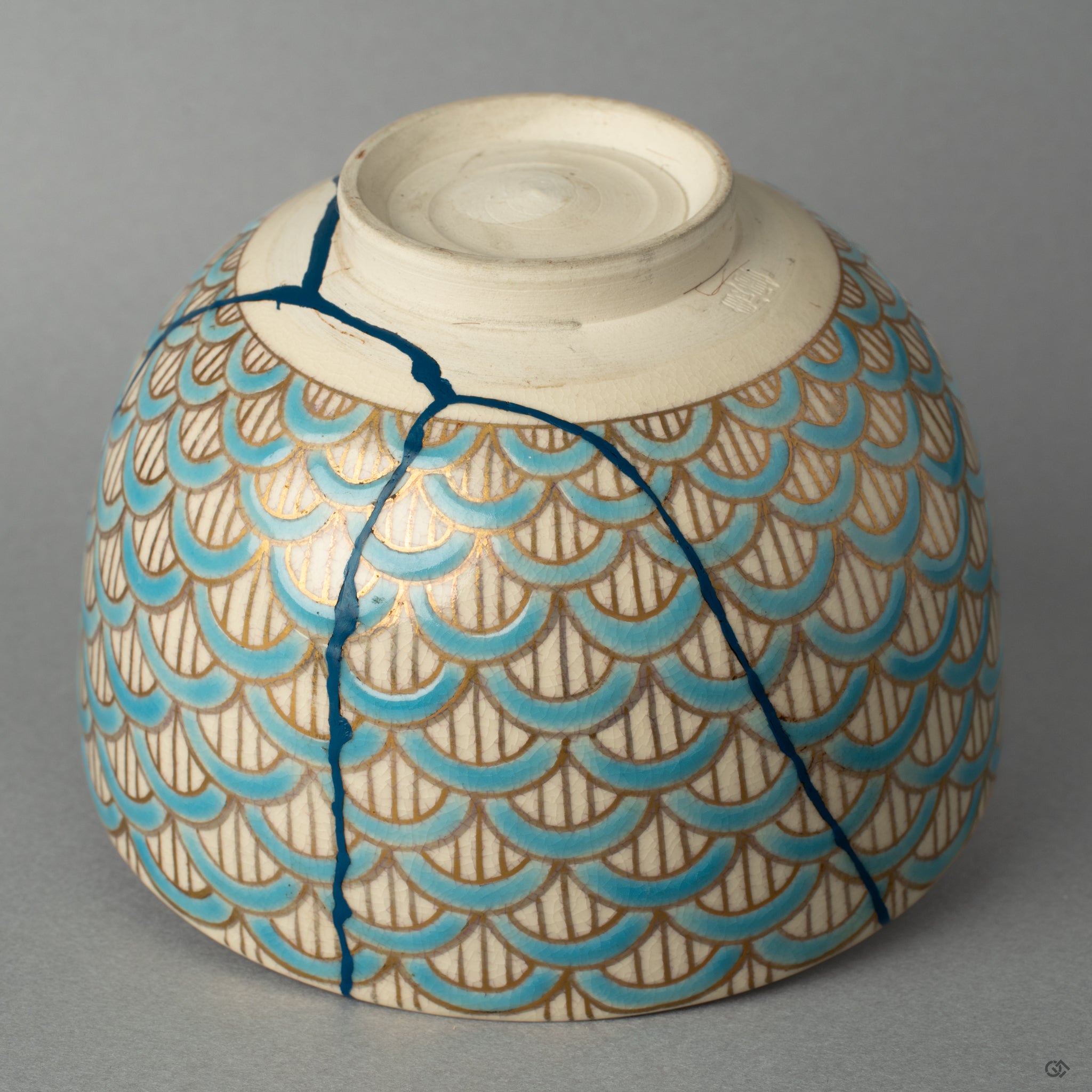 The rich texture of the kintsugi repairs made visible, a tactile history of the bowls journey, transformed by the artists hand.