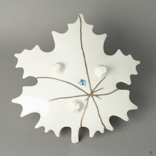 The reverse side of the Arita ware maple leaf dish, revealing a delicate network of pure silver Kintsugi lines. This hidden beauty offers a striking contrast to the vermillion top, showcasing the multifaceted nature of this unique artwork.