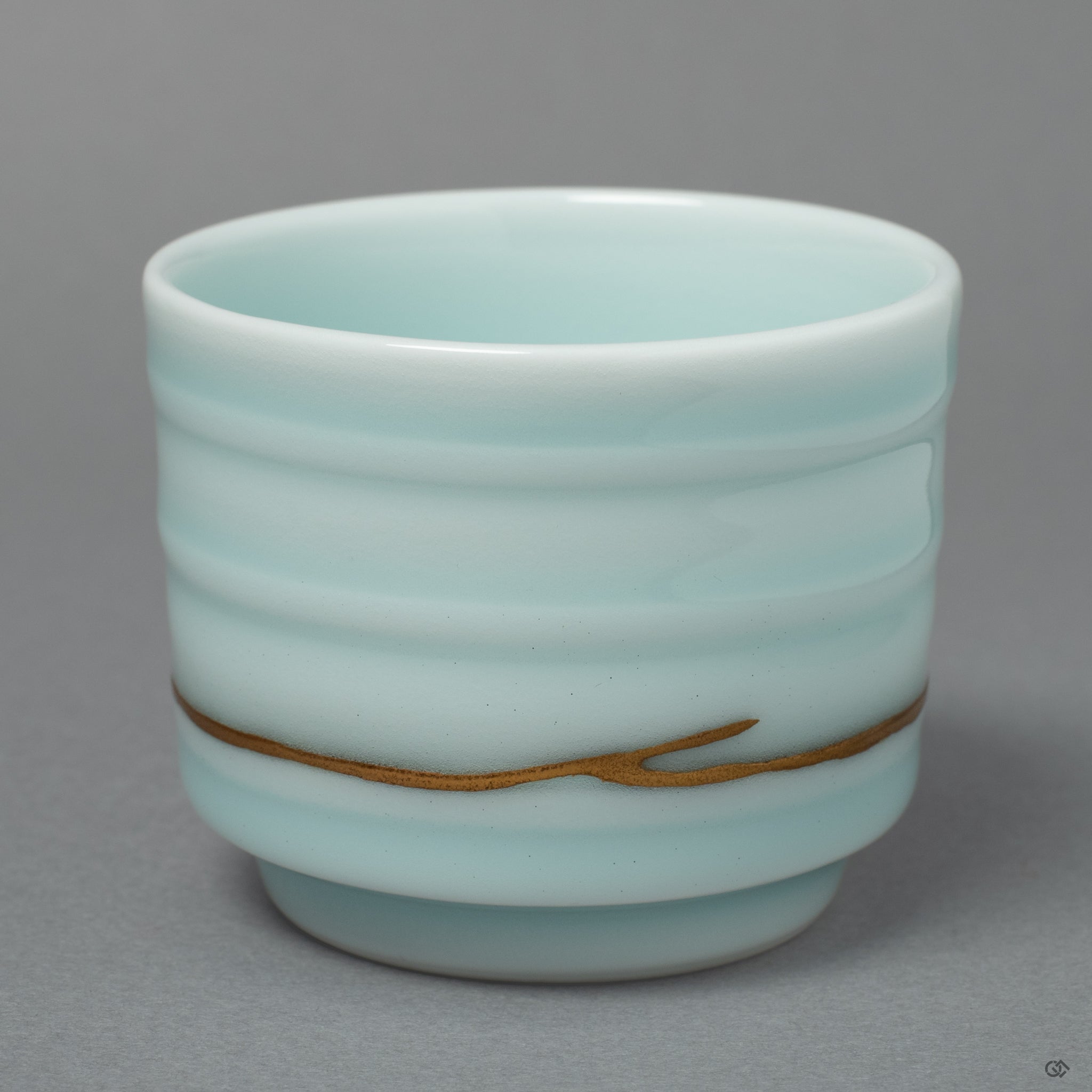 The serene form of an Arita ware sake cup, its story honored by fine seams of 24k gold Kintsugi that trace a path of quiet beauty.