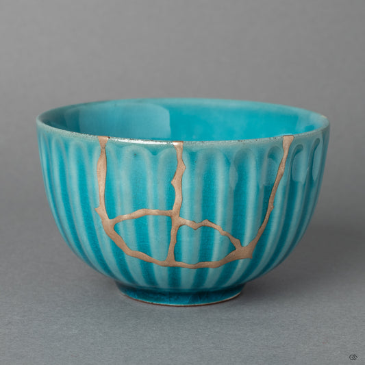 The elegant form of an Arita ware porcelain sake cup, its story honored by the quiet luster of fine silver Kintsugi seams.