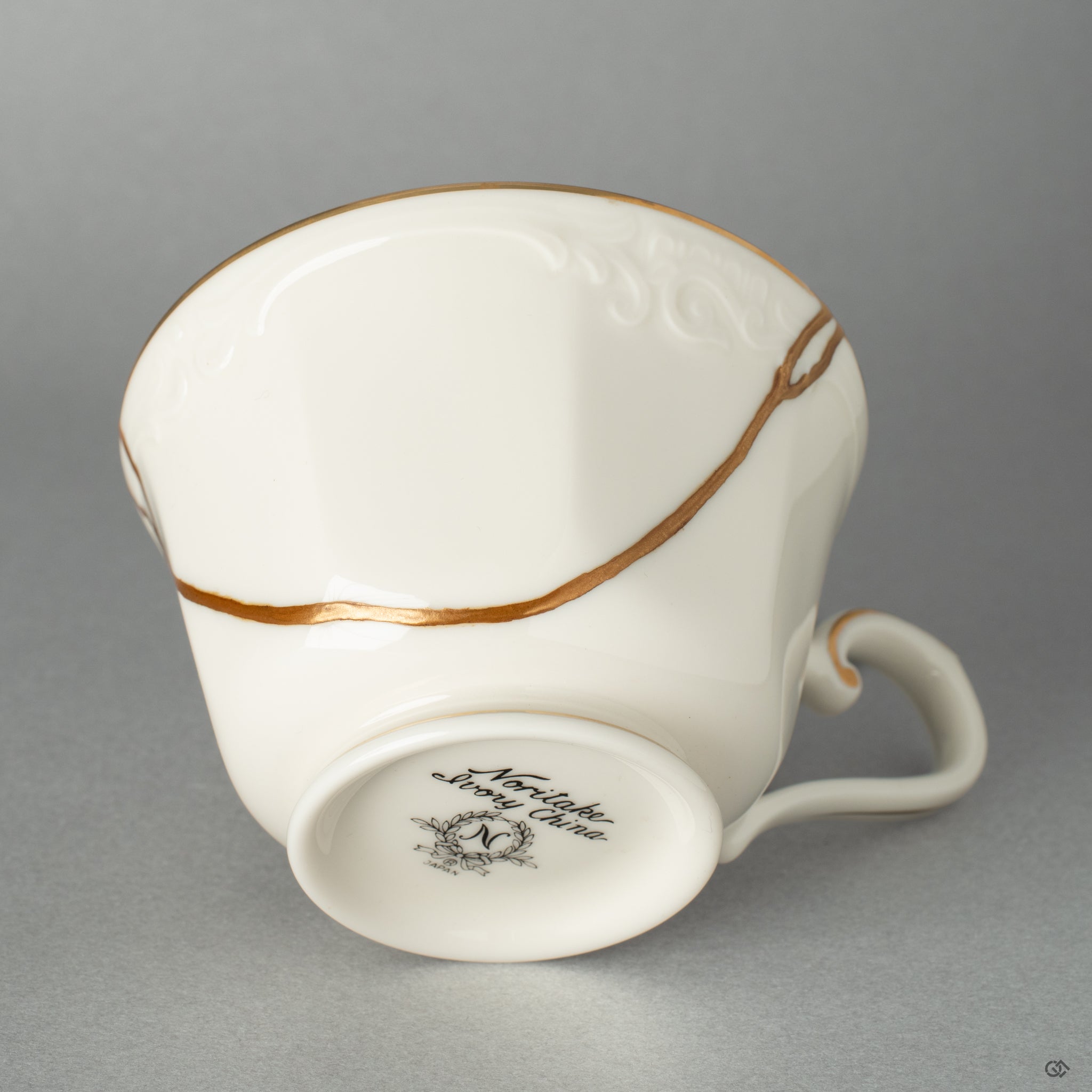 Macro view of a repaired artifact, where gleaming gold lacquer transforms a flaw into a feature of profound beauty.