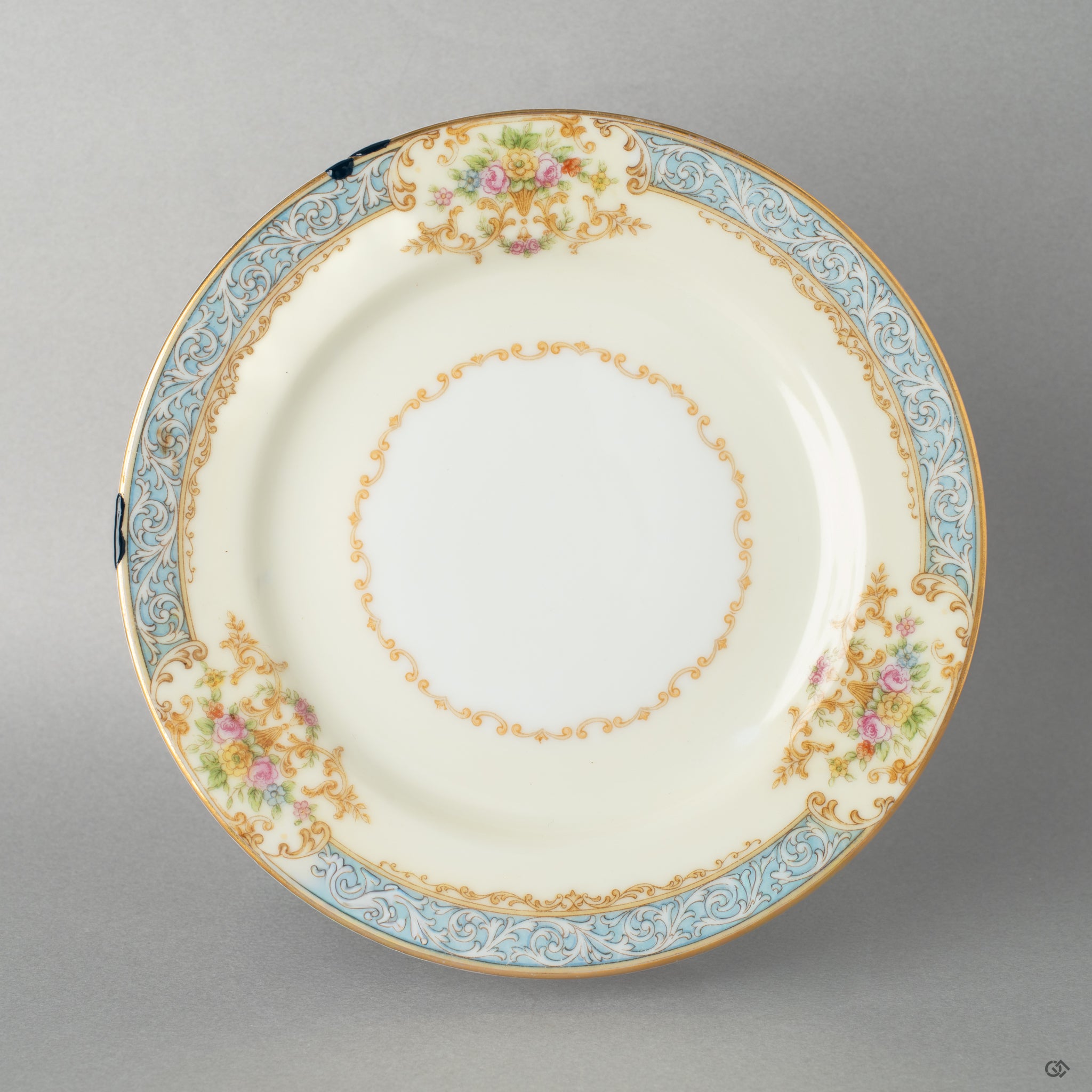 An Early Noritake kintsugi saucer on a linen tablecloth, its golden repair shining, a perfect vessel for intentional living.