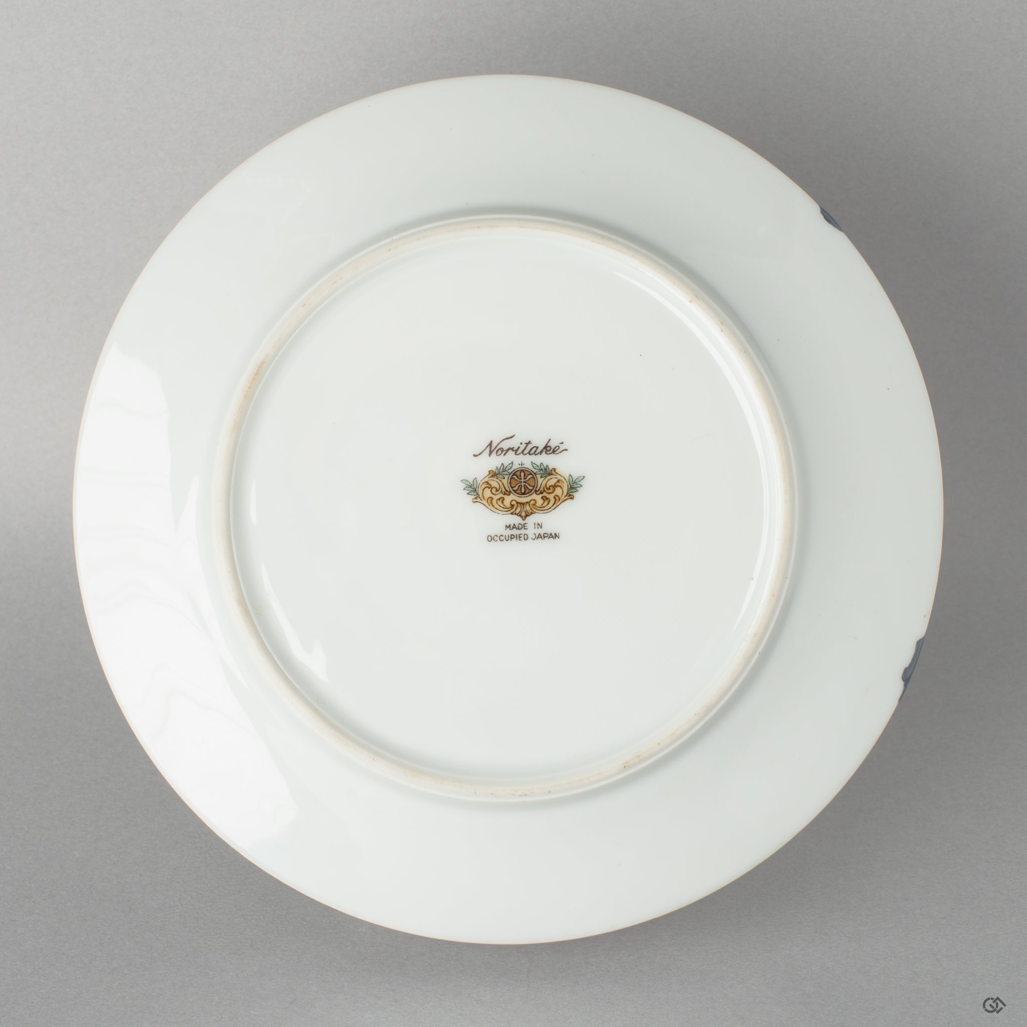 View of the elegant Noritake saucer, its form complemented by the subtle kintsugi repair, an expression of a quiet beauty.