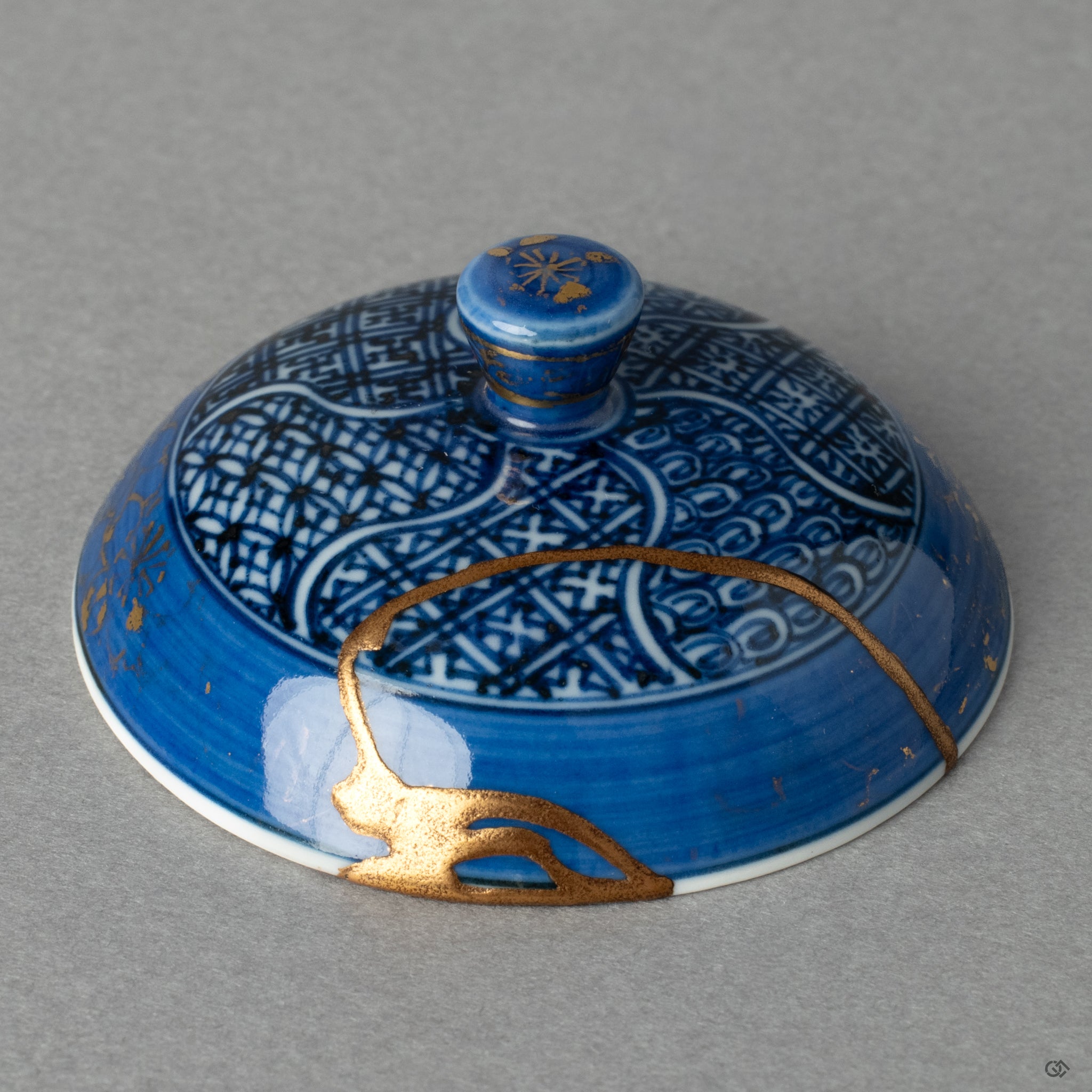 A close-up of the kintsugi on the lid, where radiant gold meets quiet black lacquer, telling a profound story in every seam of its thoughtful healing.