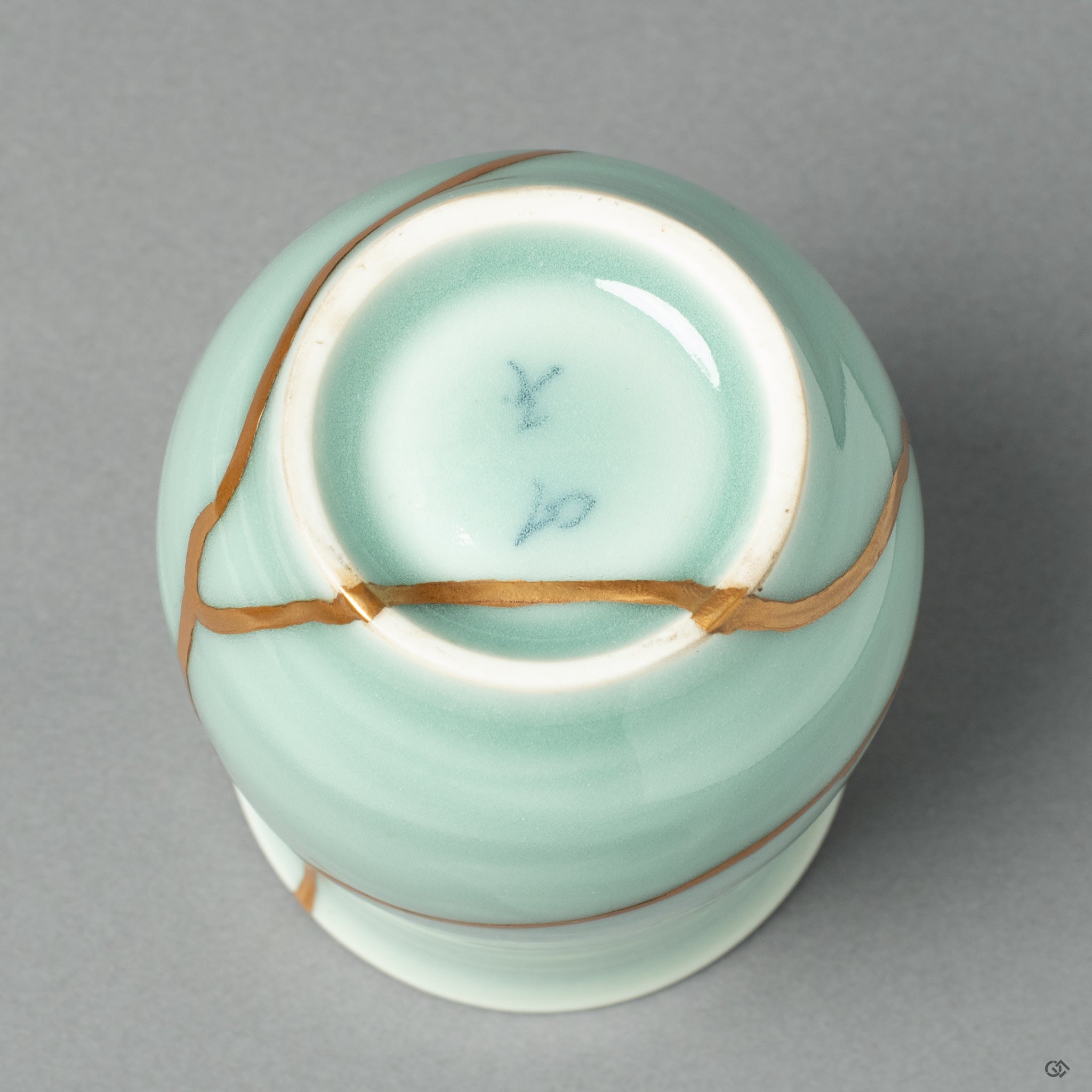 View of the footed base of the Nabeshima ware tea cup, showing the continuation of the 24k gold Kintsugi repair on the piece's underside.