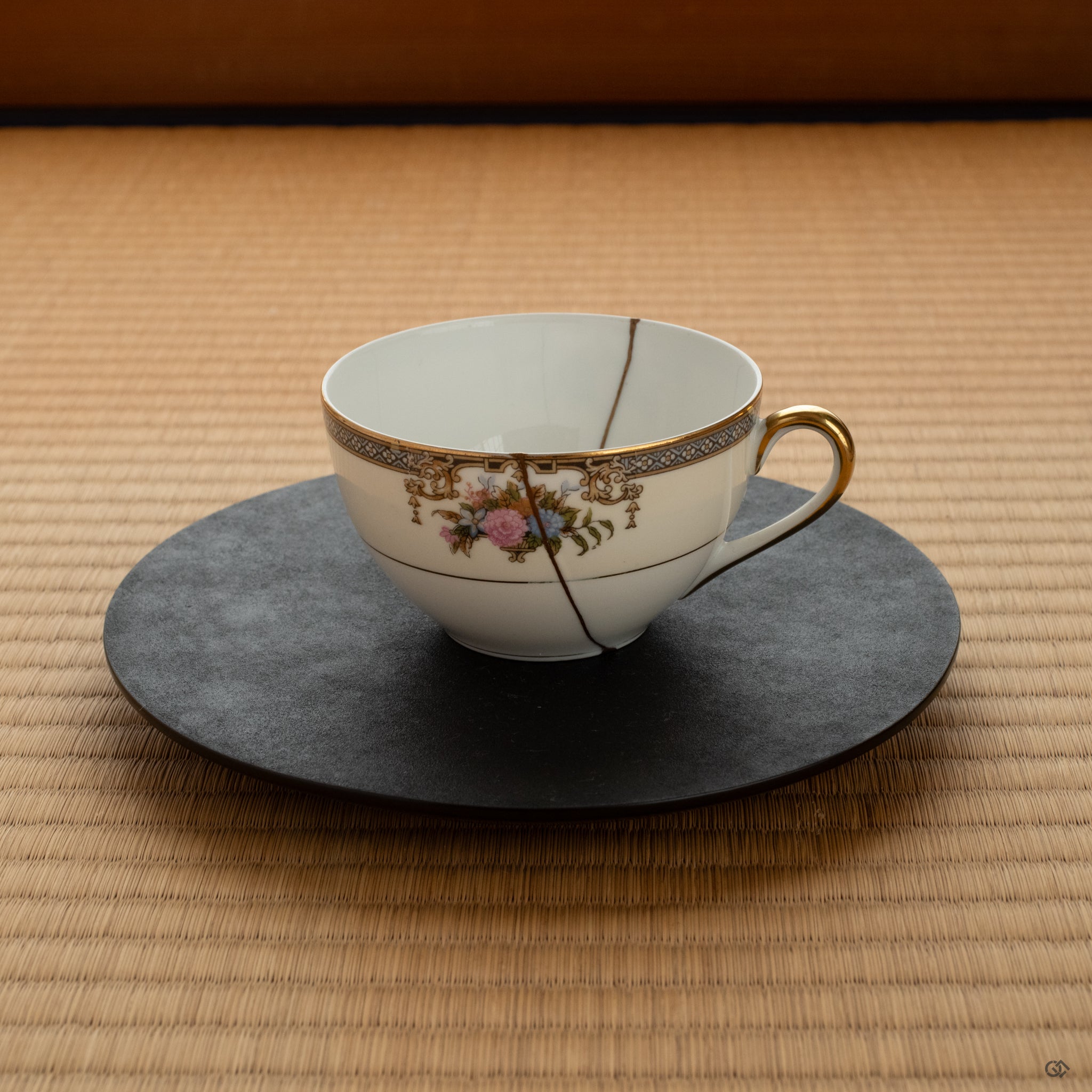 A Kintsugi tea cup set on a black plate over tatami, framed by shoji screens—evoking Japanese wabi-sabi elegance and quiet refinement.