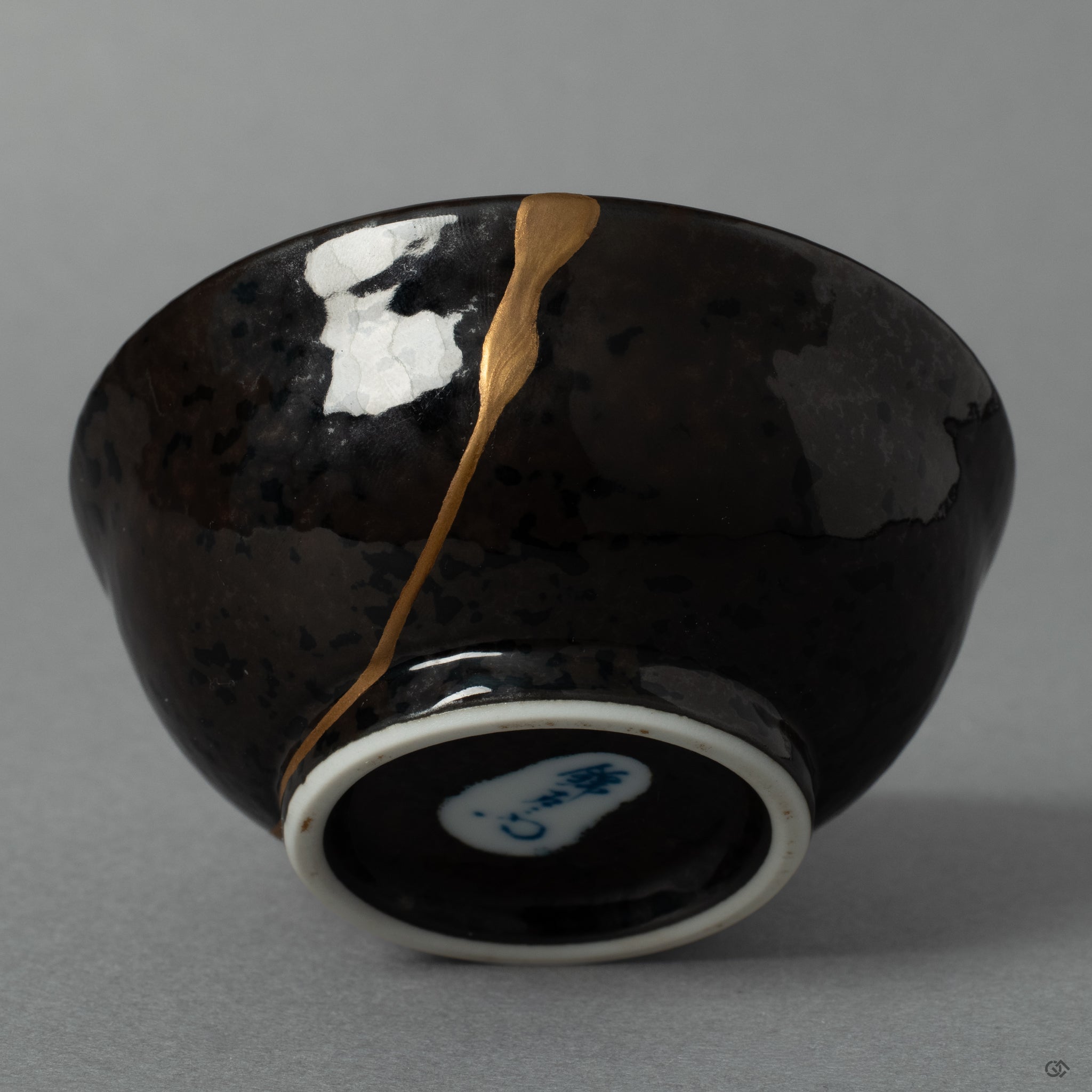 A macro view of a delicate maki-e branch growing from the golden seam, a beautiful expression of the art of urushi lacquer and renewal.