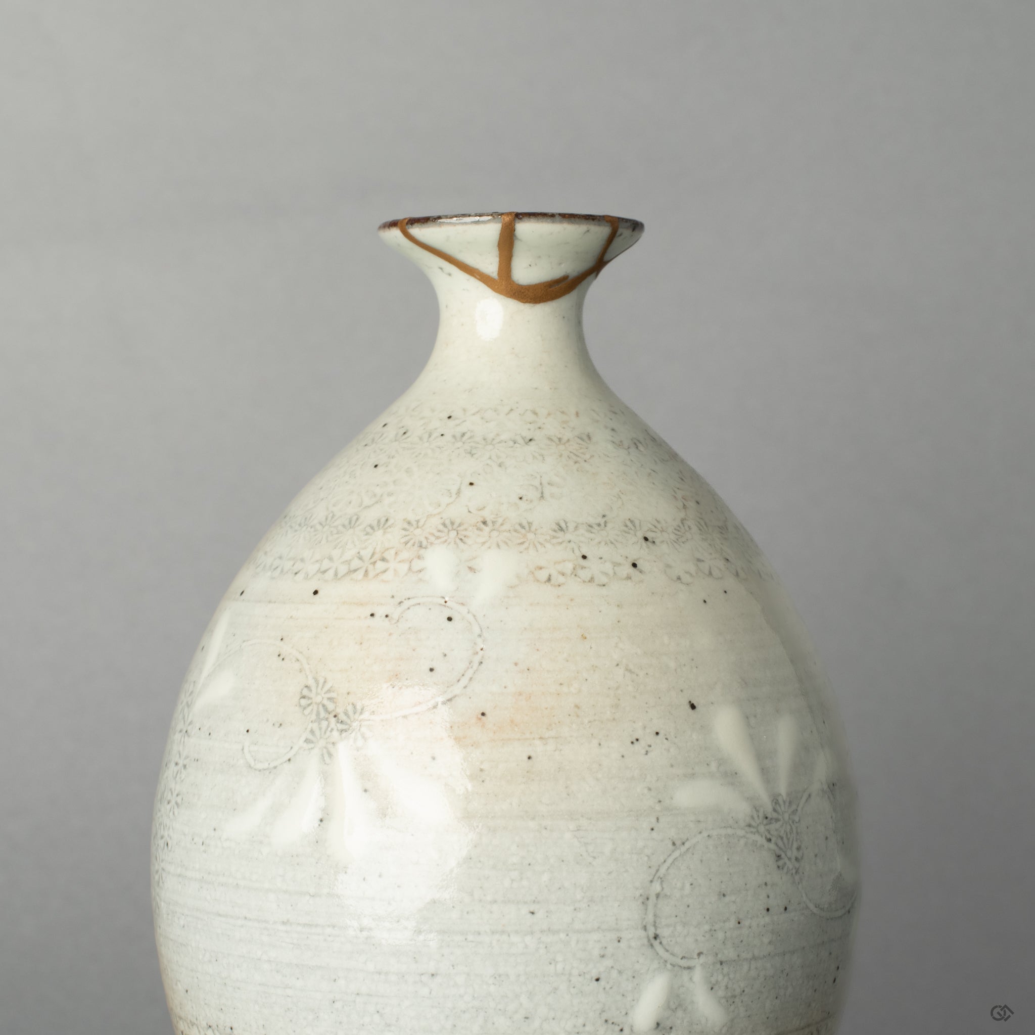 The shining 24K gold kintsugi seam on the ceramic surface, a quiet moment where the vessels journey becomes history made visible.