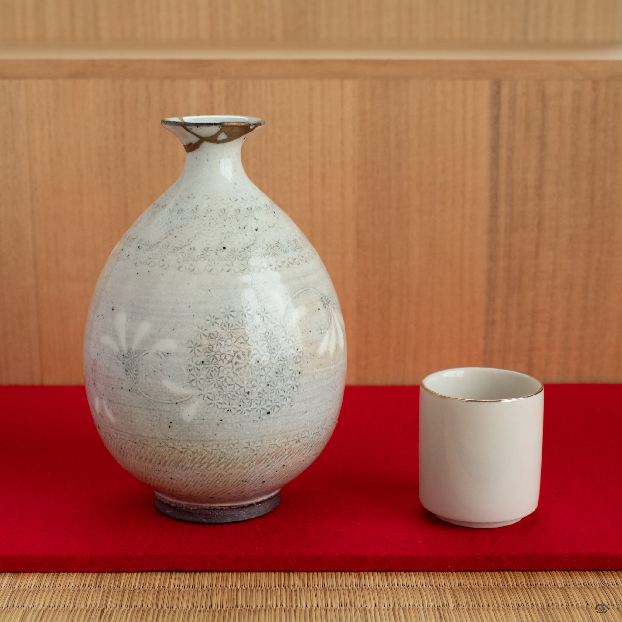 The kintsugi tokkuri put on the tatami and red felt, creating a moment of connection between the user, the vessel, and its renewed life.