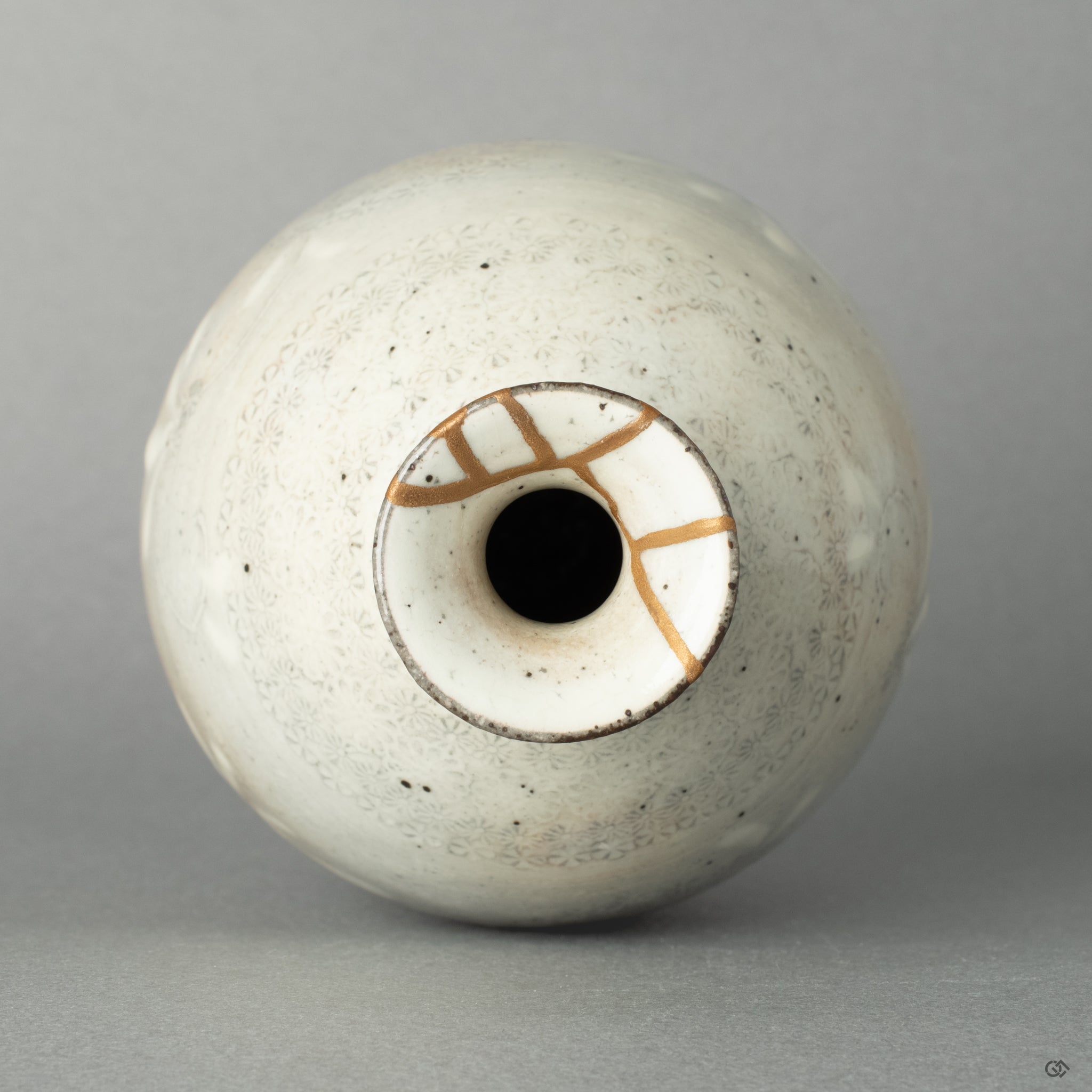 A top-down view into the mouth of the kintsugi tokkuri, its golden repair inviting a moment of contemplation before sake is poured.