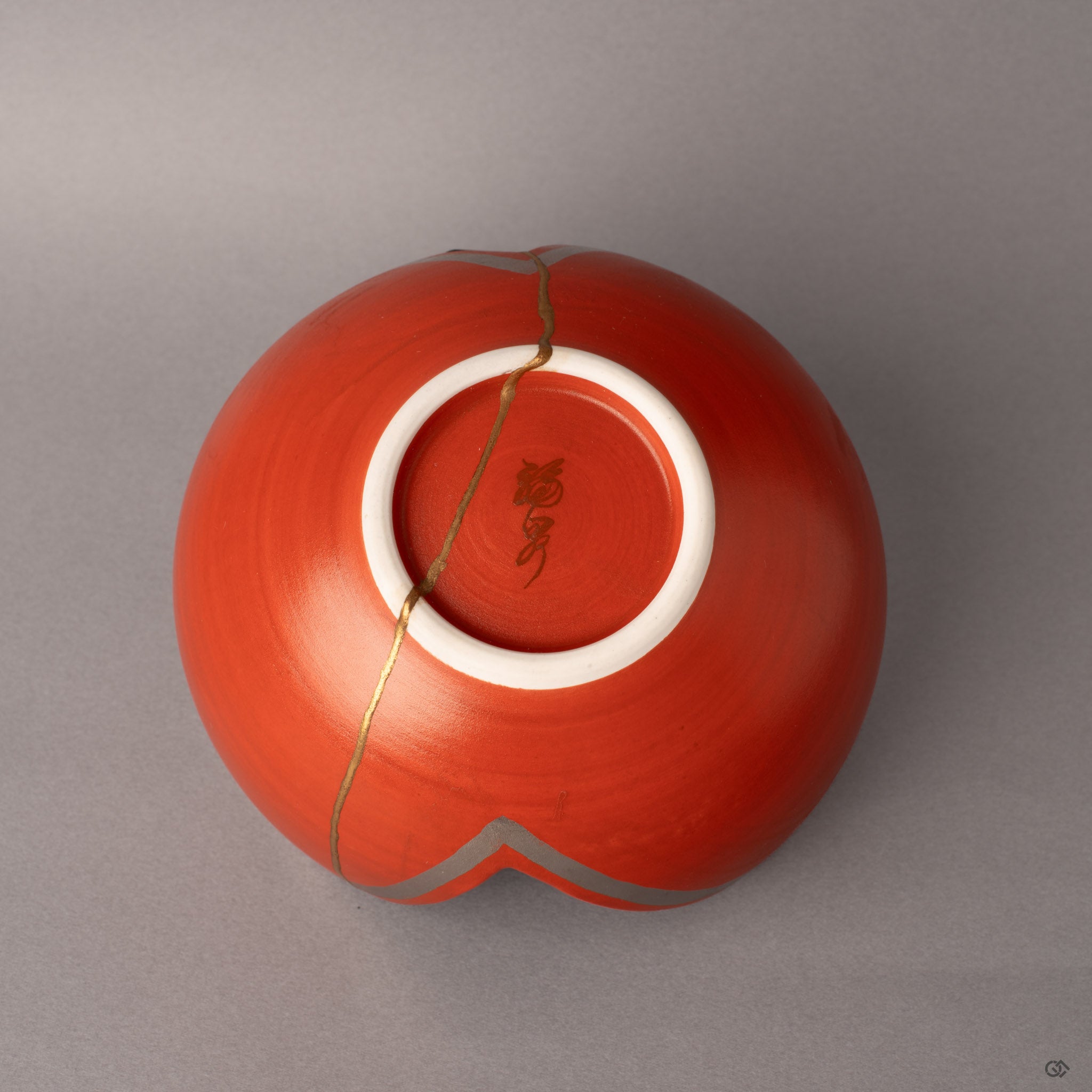 The potter's seal marks this Arita kintsugi bowl's origin, gold seams visible even beneath the sculptural form.