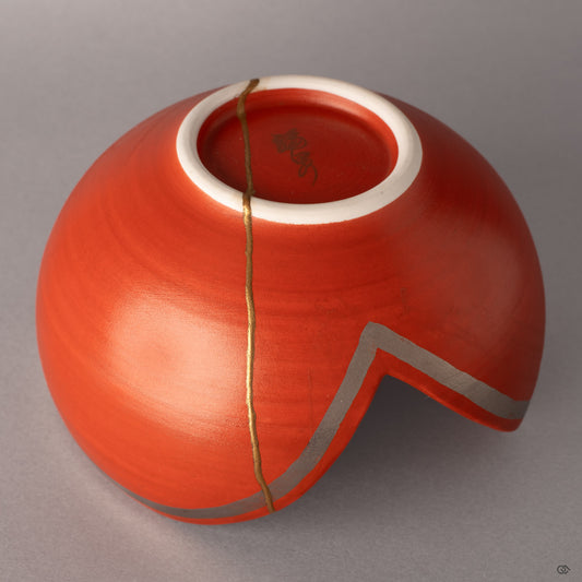 Gold kintsugi rivers carve new geography across vermillion Arita porcelain, each seam a story of resilience.