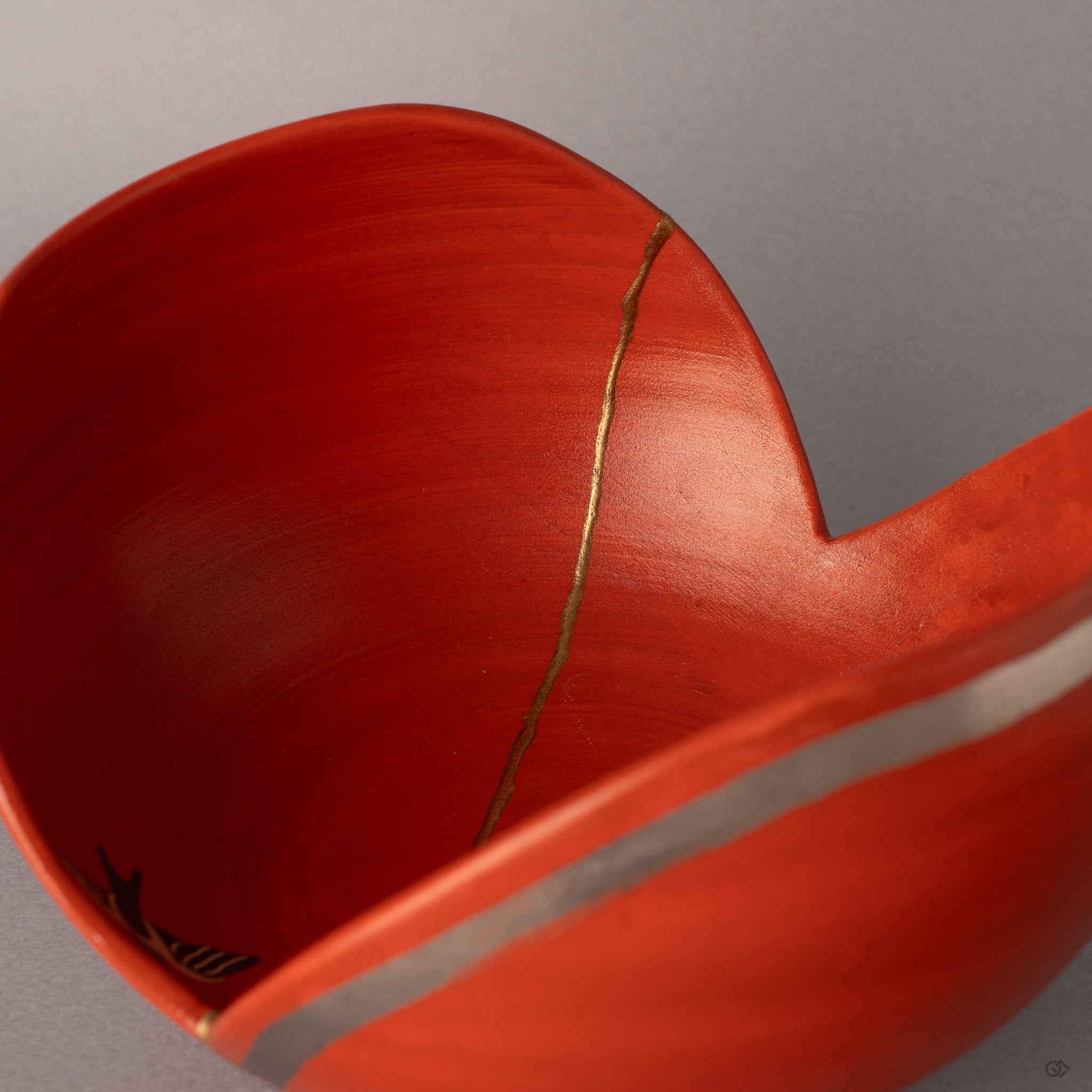 Inside this Arita kintsugi bowl, gold threads weave through vermillion, a meditation on visible mending.