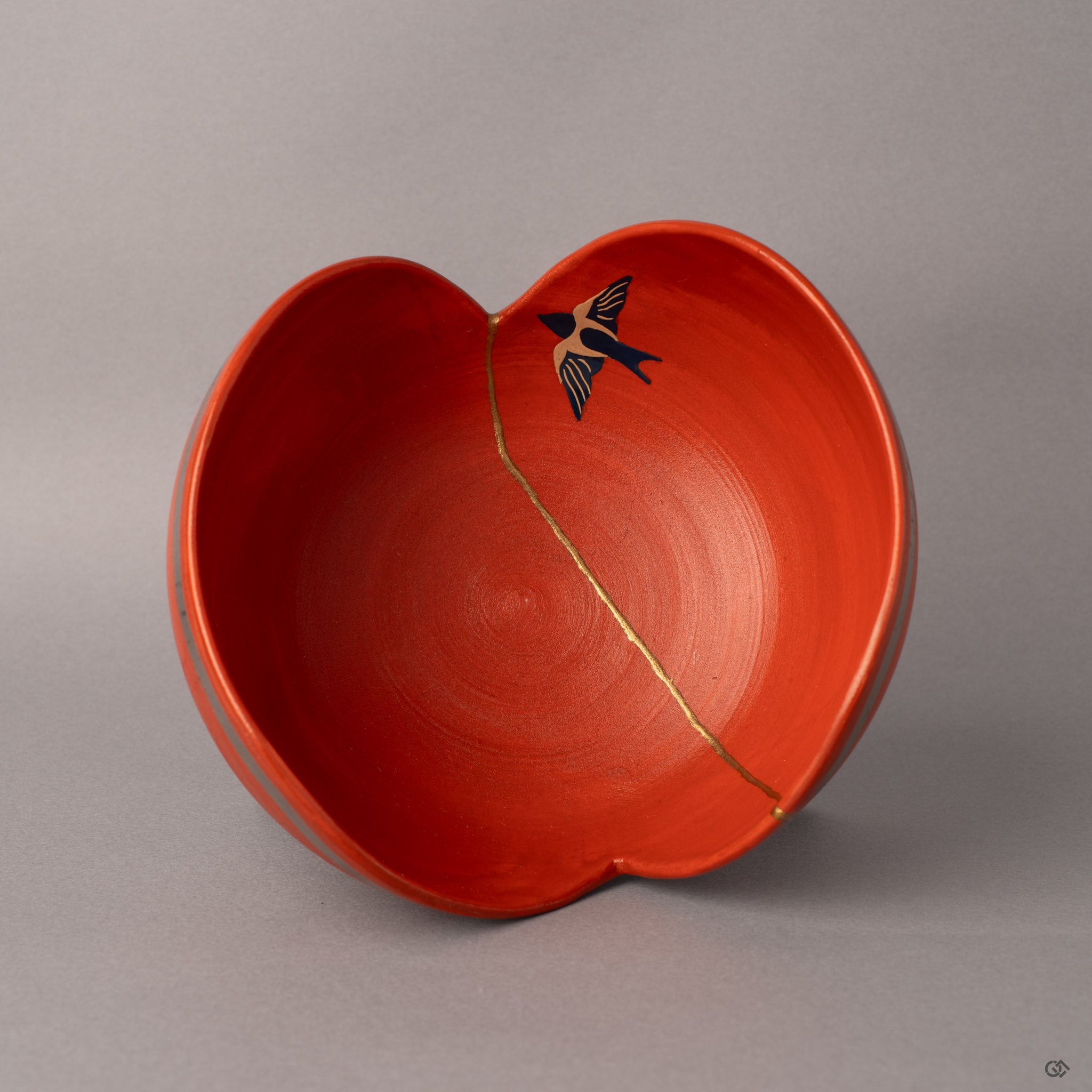 Looking into this Arita kintsugi bowl reveals the hand-painted swallow soaring across mended red porcelain.