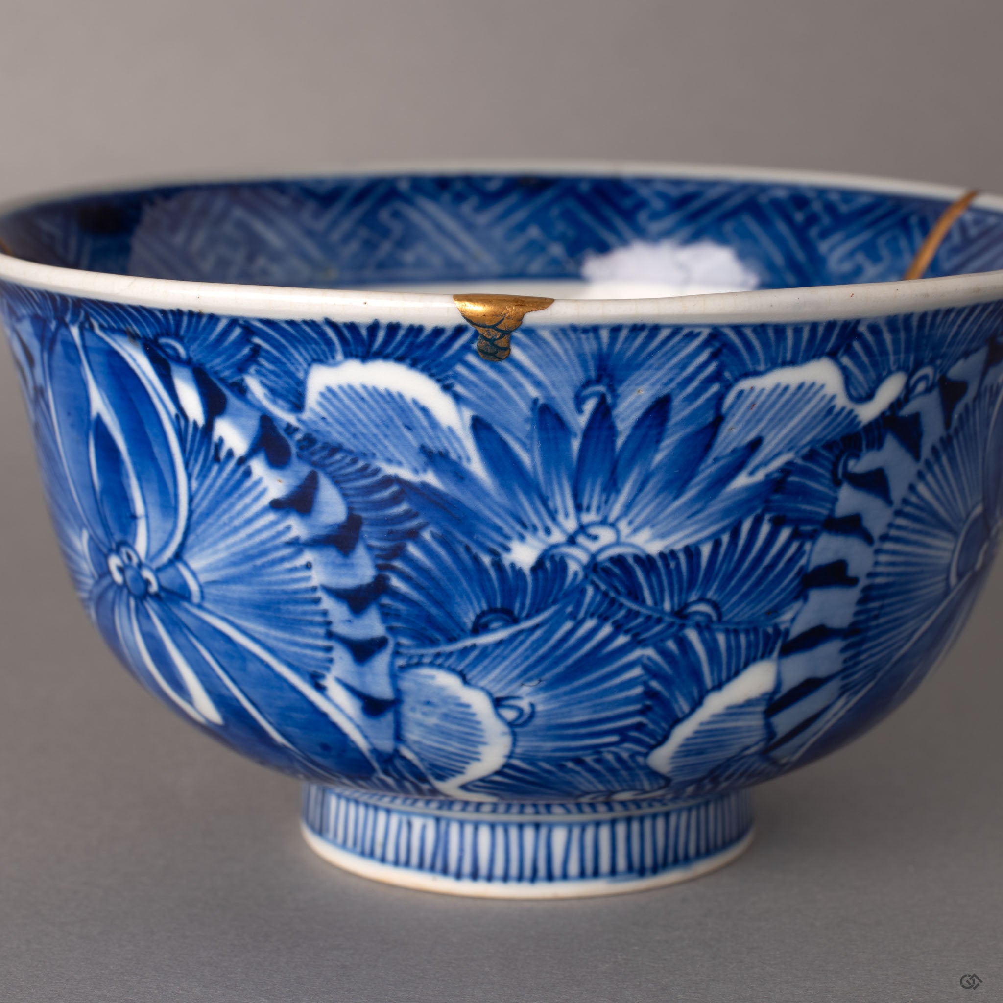 Restored chip on the rim of a Ko-Imari kintsugi bowl, 24K gold over natural urushi lacquer on sometsuke porcelain, restorative beauty.