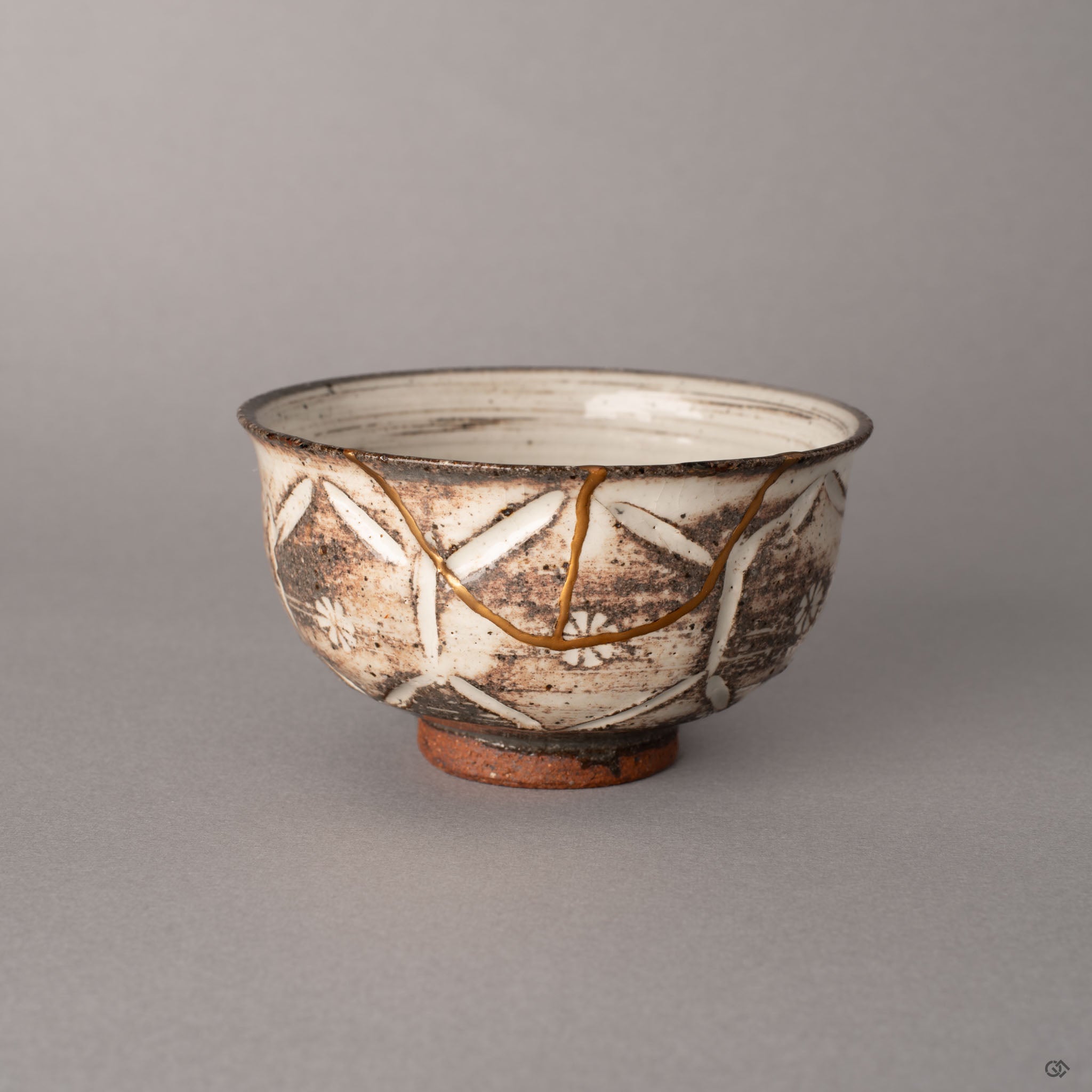 Kintsugi Kyoto ware cup with 24K gold seams over hori-mishima carved earthenware in cream and warm brown, a quiet beauty rooted in tea tradition.