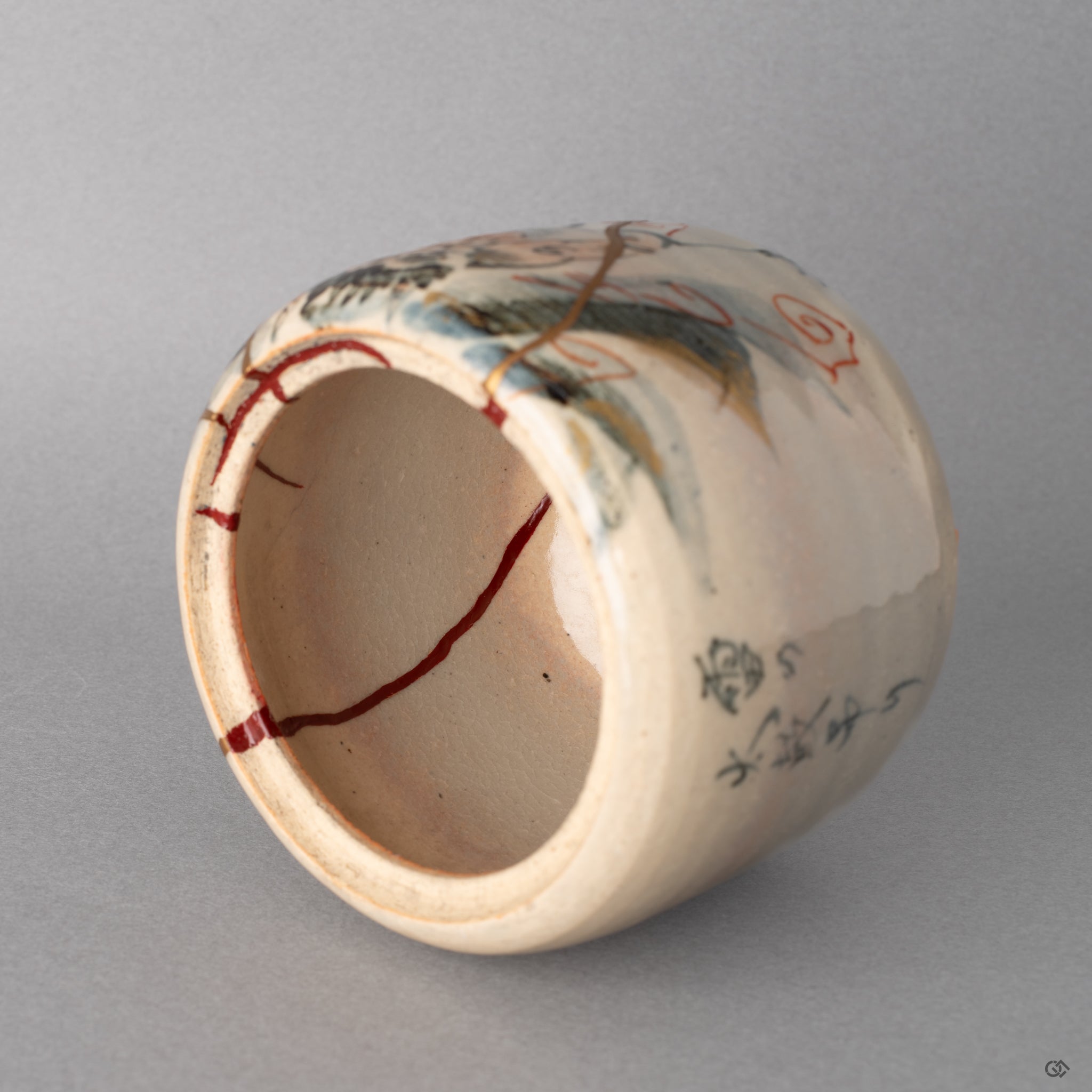 Close view of the red urushi kintsugi lacquer. This masterful repair adds a quiet beauty to the deep vessel's interior.