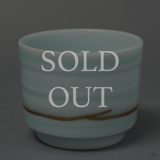 A beautiful celadon glazed Japanese Kintsugi cup with a delicate gold seam, now in a private collection. An example of the unique artworks we curate.