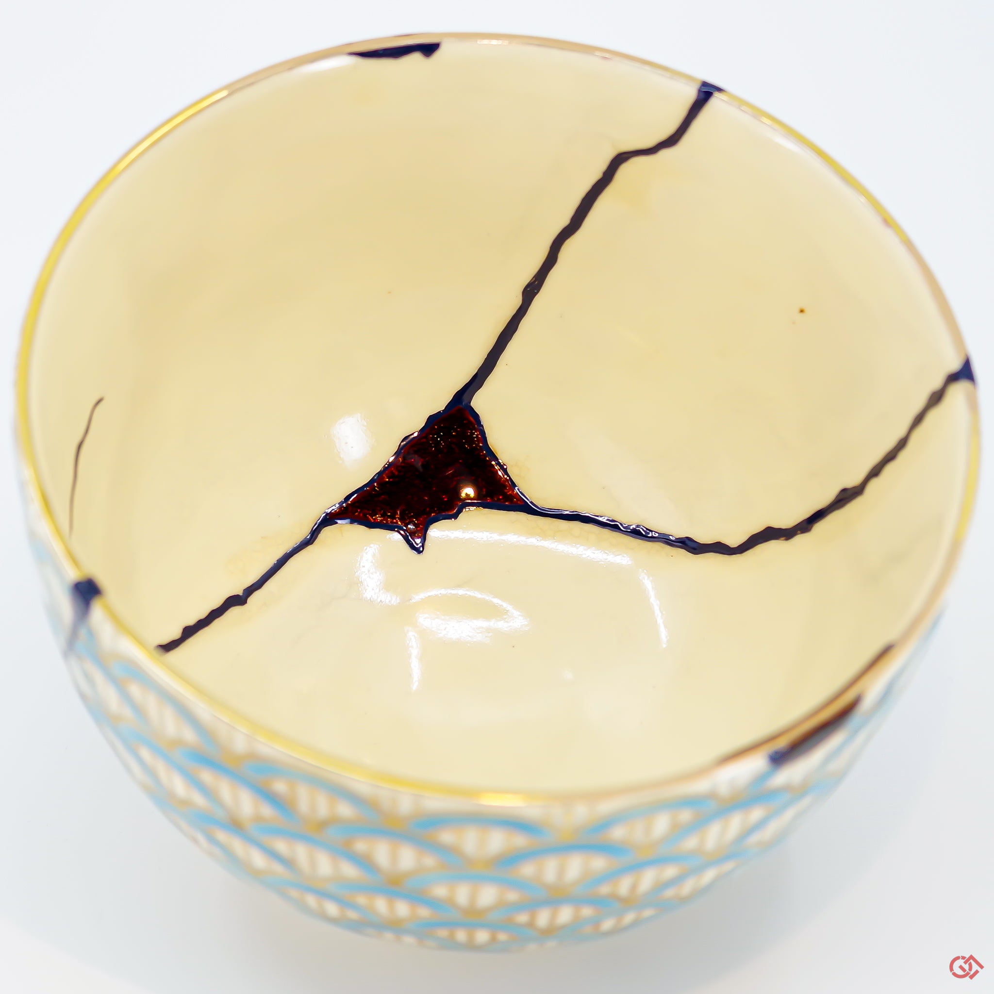 A close-up photo of an authentic Kintsugi pottery piece, showing the detail of its repairs and craftsmanship.