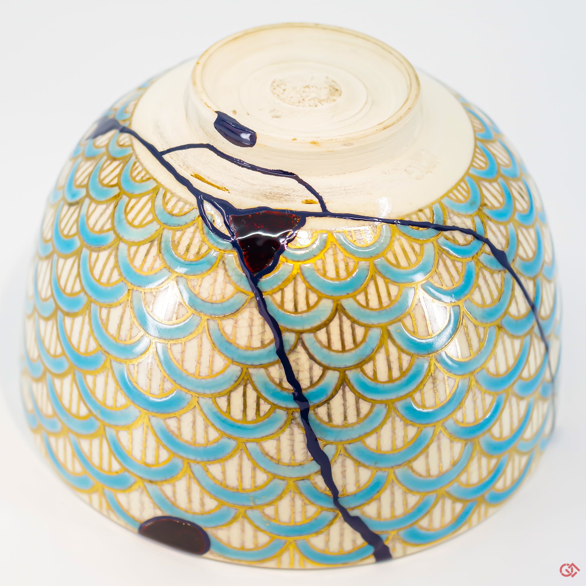A close-up photo of an authentic Kintsugi pottery piece, showing the detail of its repairs and craftsmanship.