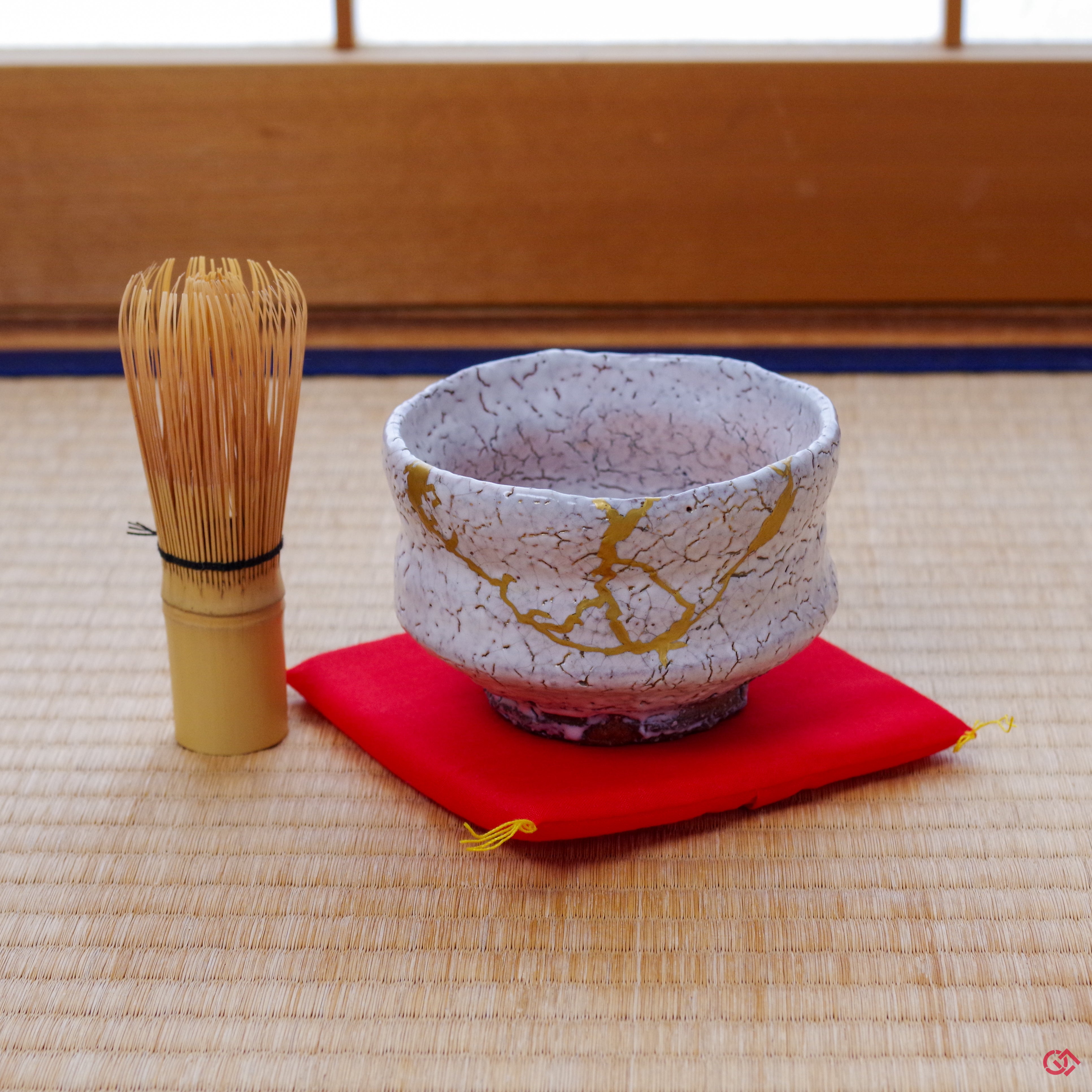 A photo of an authentic Kintsugi pottery piece being used in a real-world setting, such as a cup of sake being poured into a Kintsugi cup.