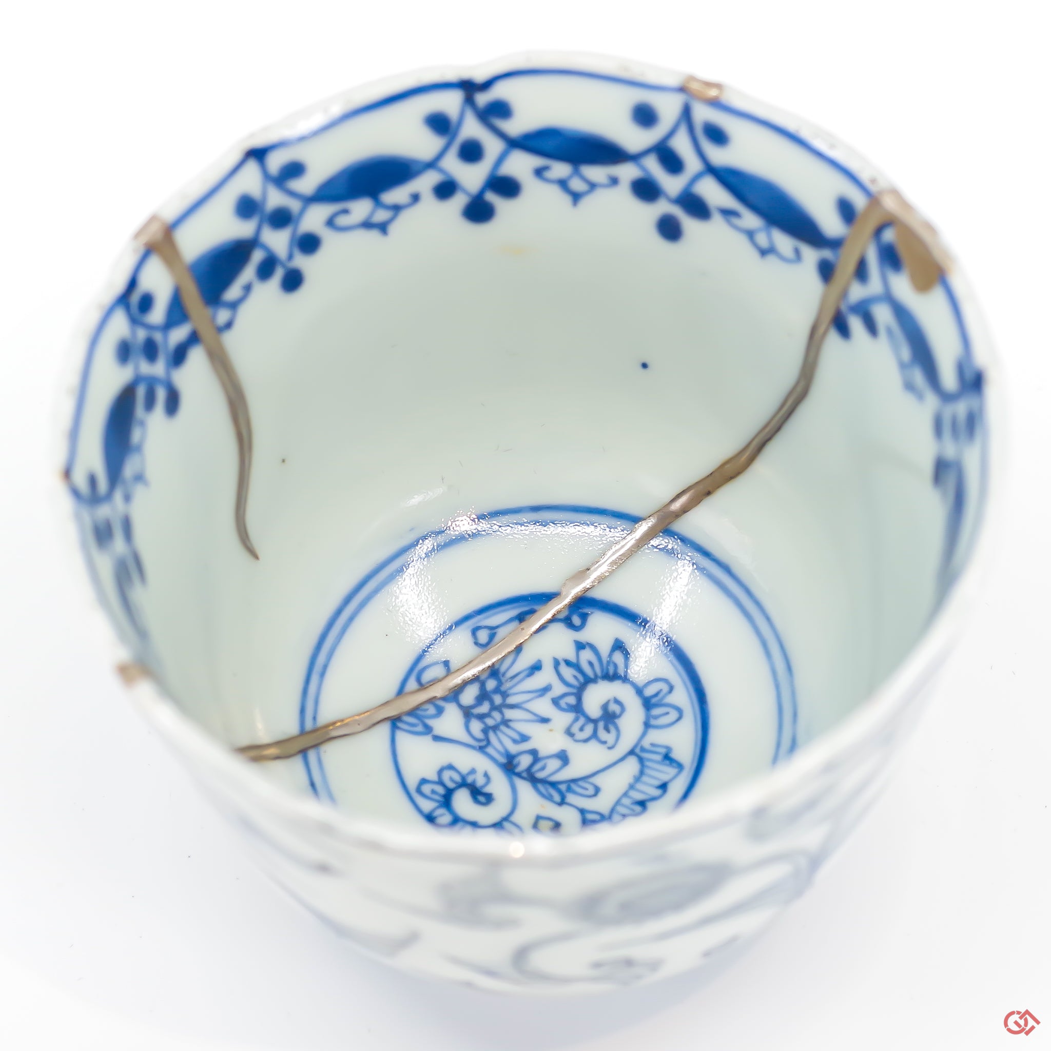 A close-up photo of an authentic Kintsugi pottery piece, showing the detail of its repairs and craftsmanship.