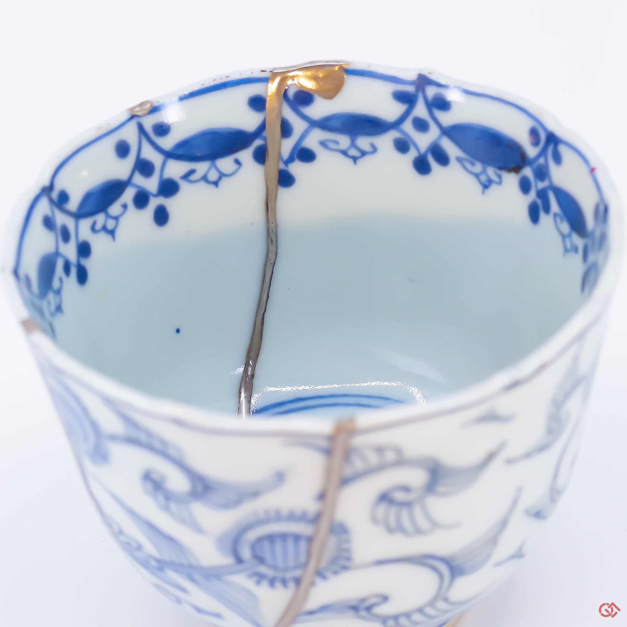 A close-up photo of an authentic Kintsugi pottery piece, showing the detail of its repairs and craftsmanship.