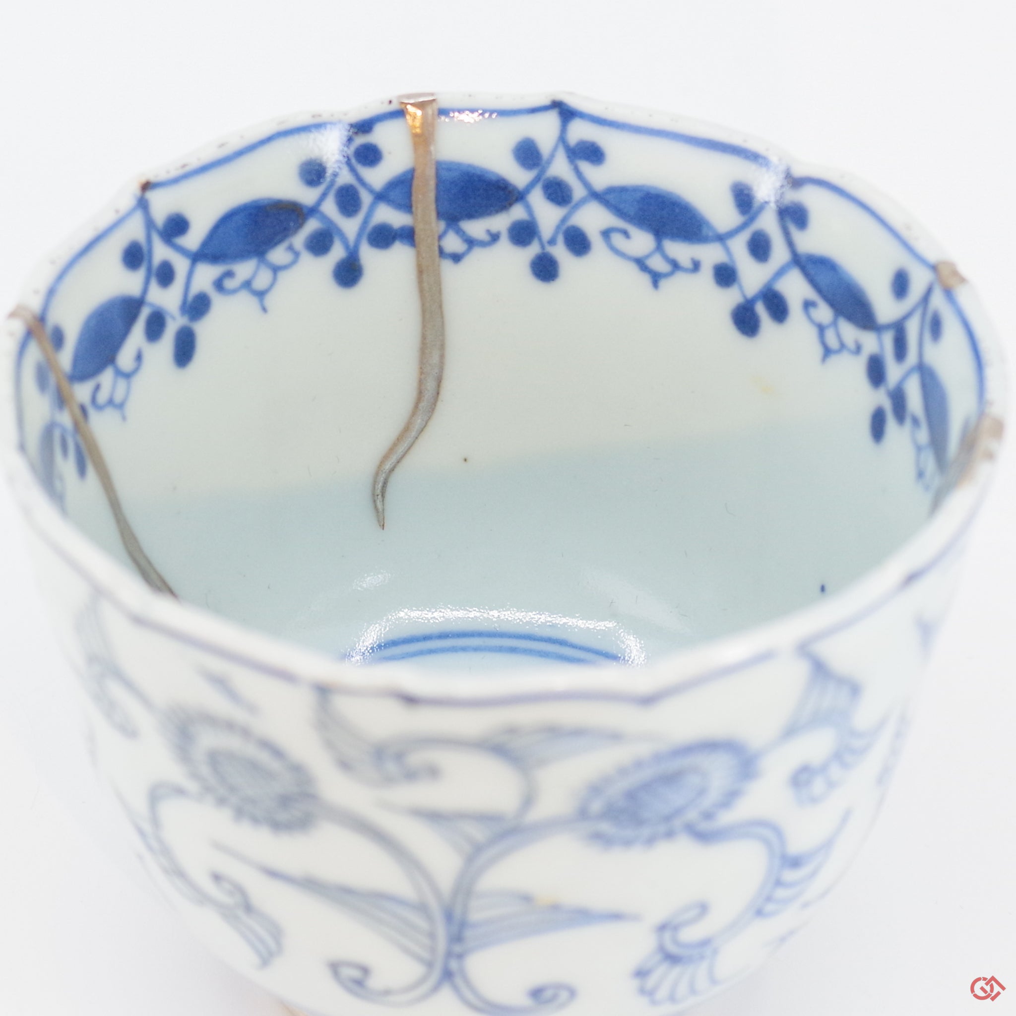 A close-up photo of an authentic Kintsugi pottery piece, showing the detail of its repairs and craftsmanship.