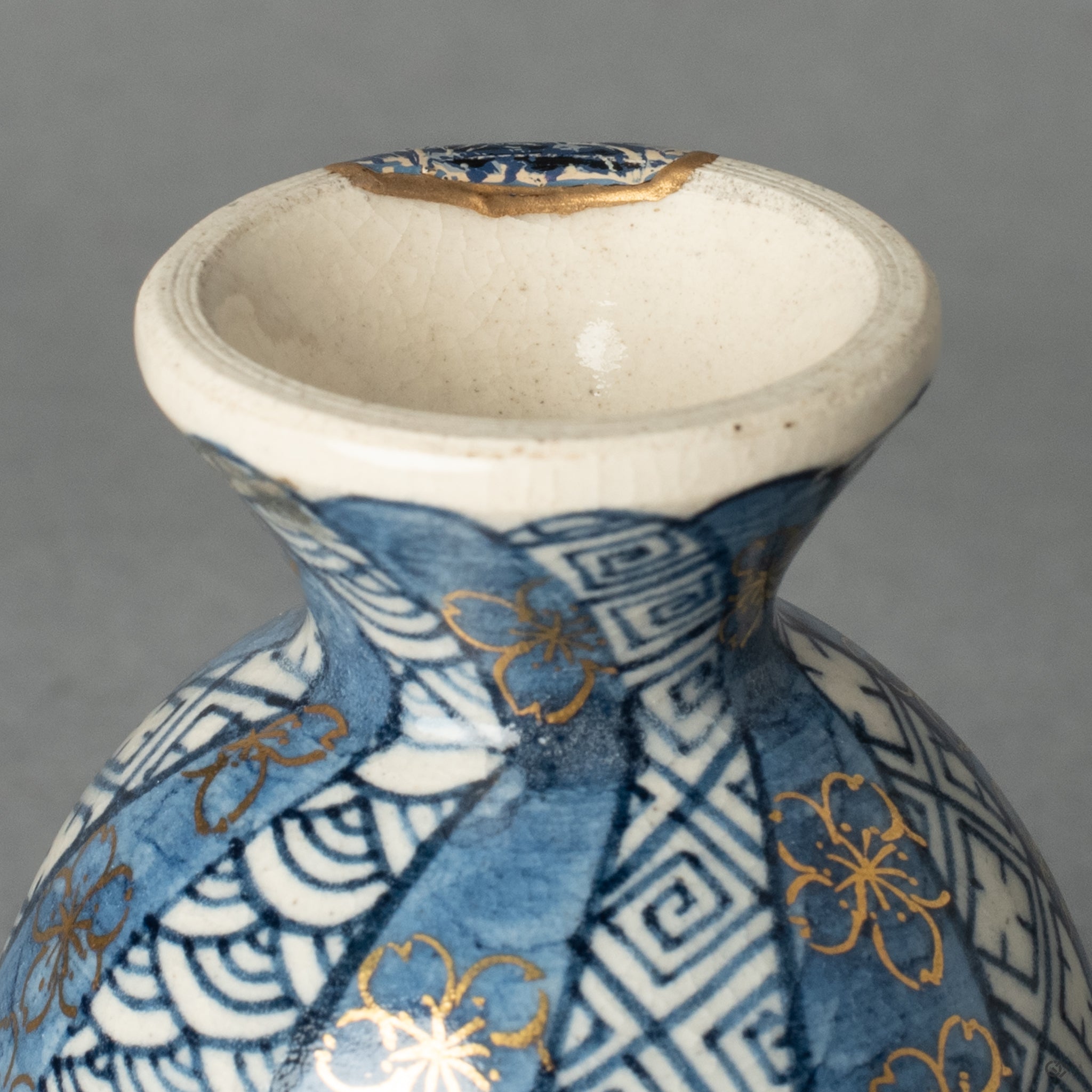 An intimate view of a pure 24k gold Kintsugi line, its soft luster flowing across the ceramic to inscribe a new chapter in the vessel's life.