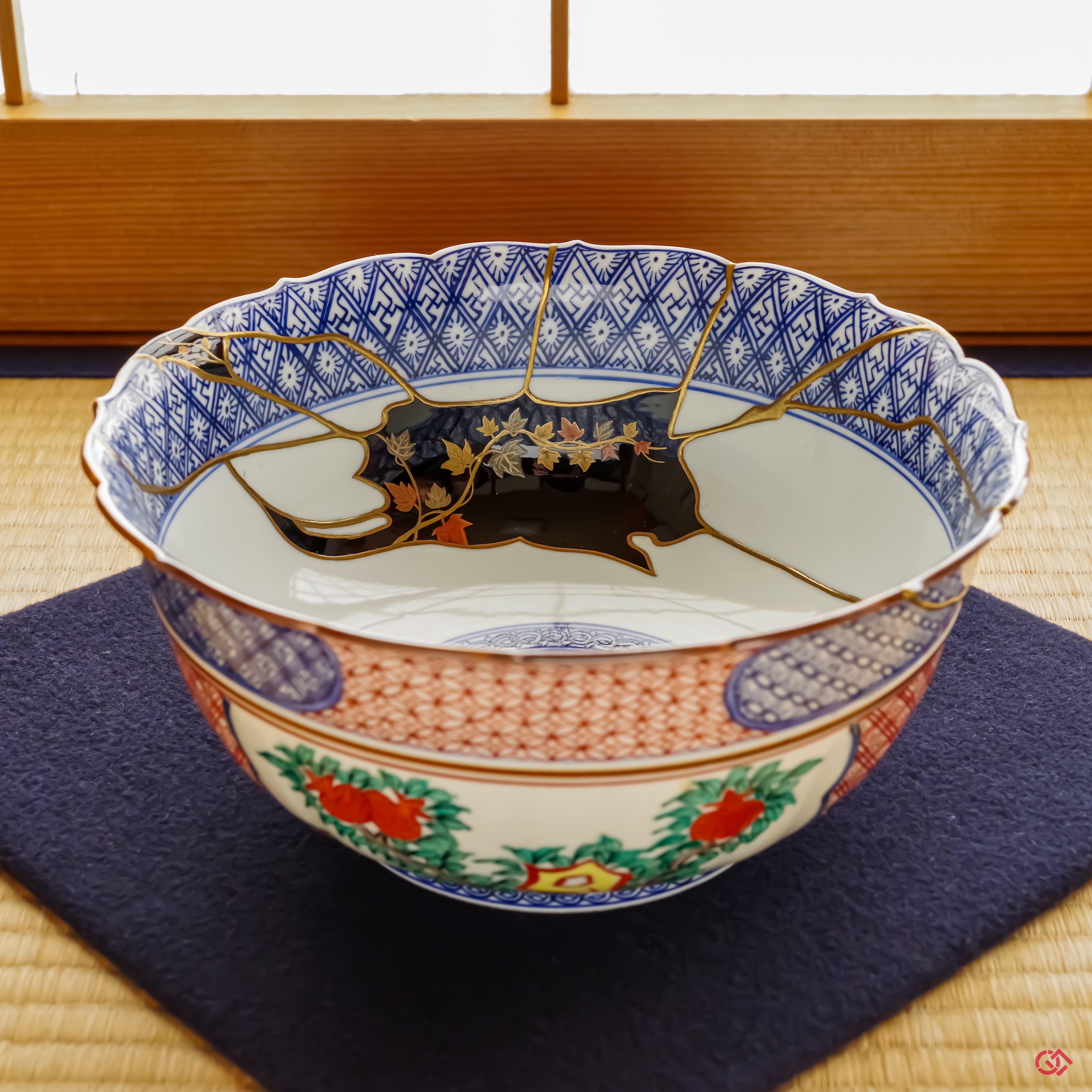 An overhead view of the Shonzui Kintsugi bowl in its tatami setting, revealing the intricate universe of repair work that continues deep inside the vessel's form, a testament to its dramatic history.