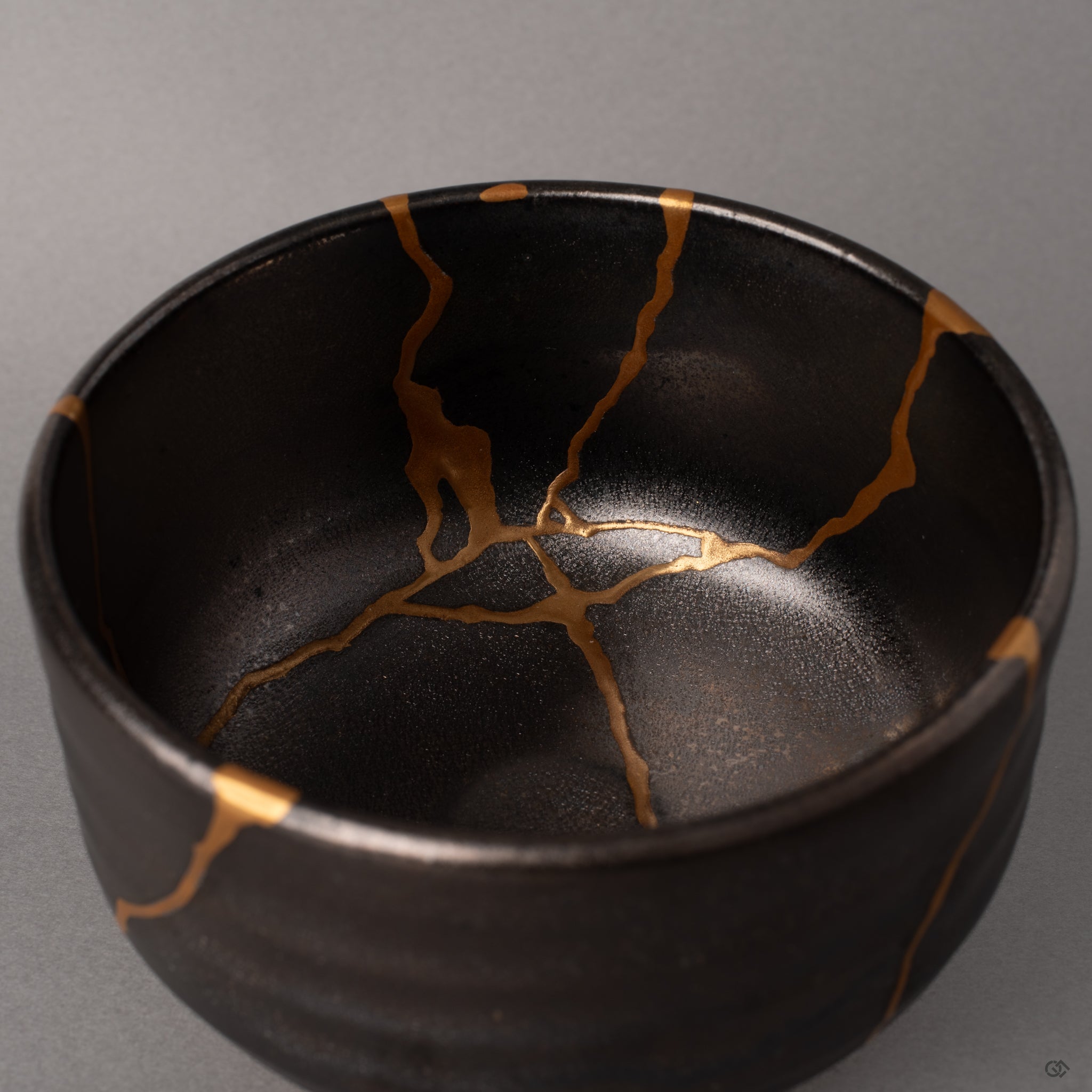 Inside the Arita bowl, urushi lacquer holds warmth beneath the gray glaze, kintsugi seams glowing with cultural heritage.