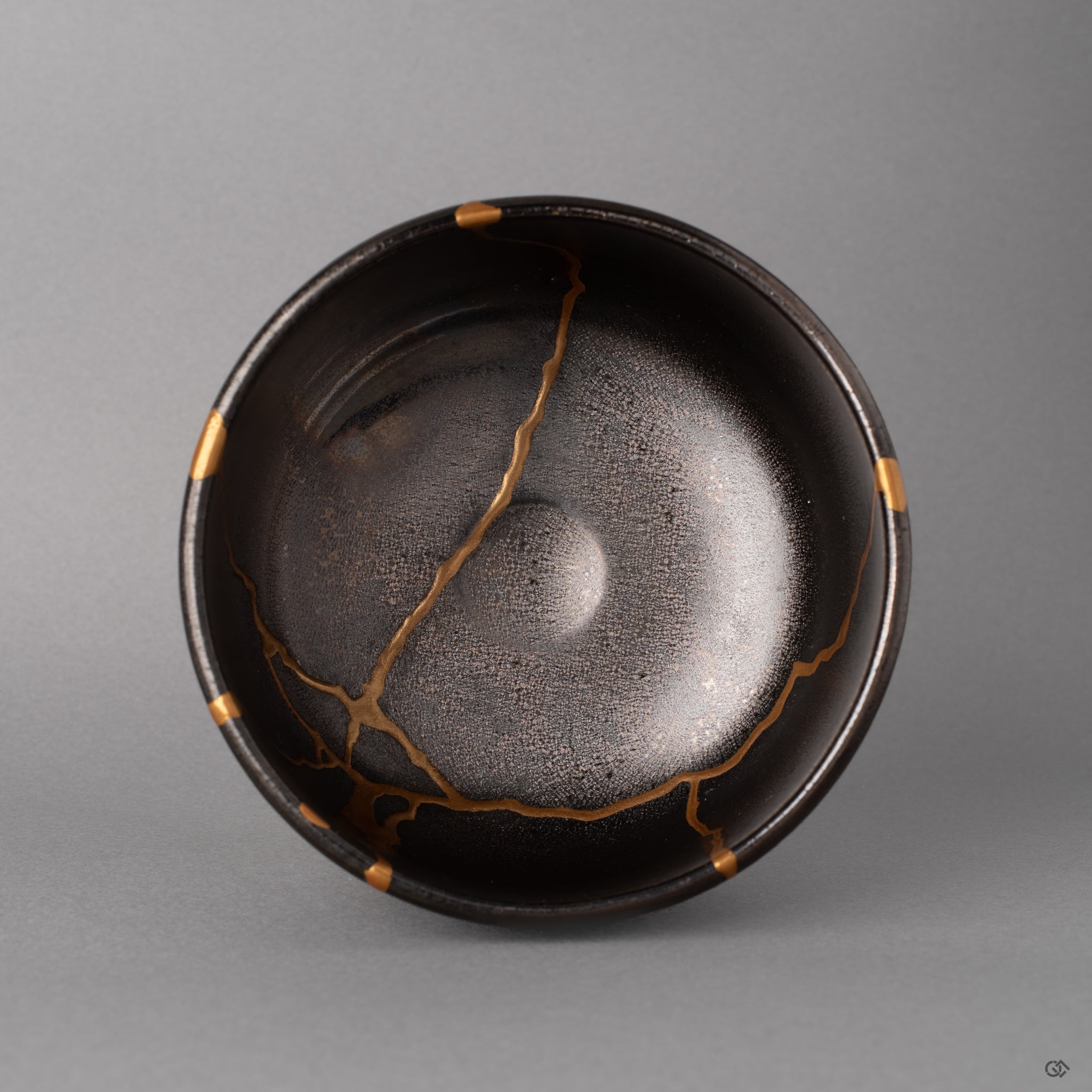 Looking into the gray Arita bowl from above, kintsugi seams radiate across the interior, a quiet beauty held in circular stillness.