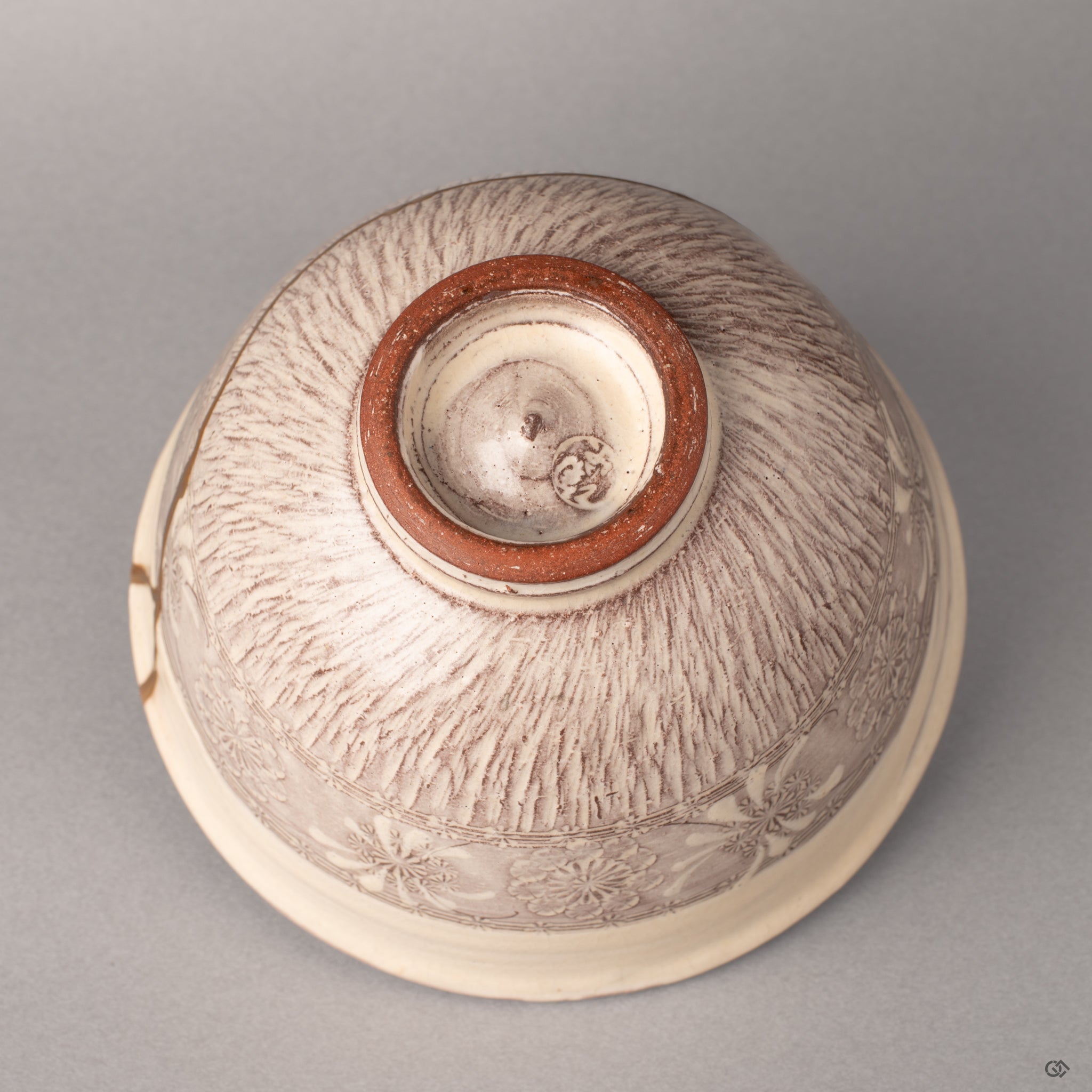 The foot ring of a Kyoto kintsugi bowl where purple glaze meets raw clay, history made visible in the foundation beneath.