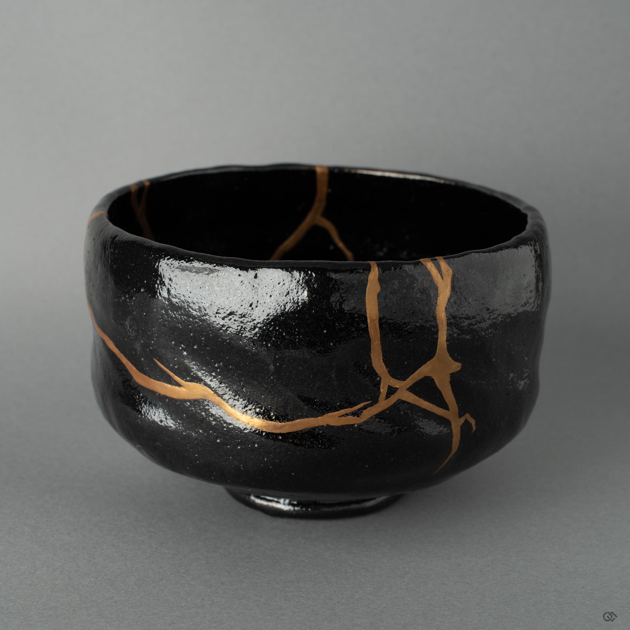 Side view of a Kyoto matcha bowl with gold kintsugi lines, the burnished surface revealing beauty in imperfection.