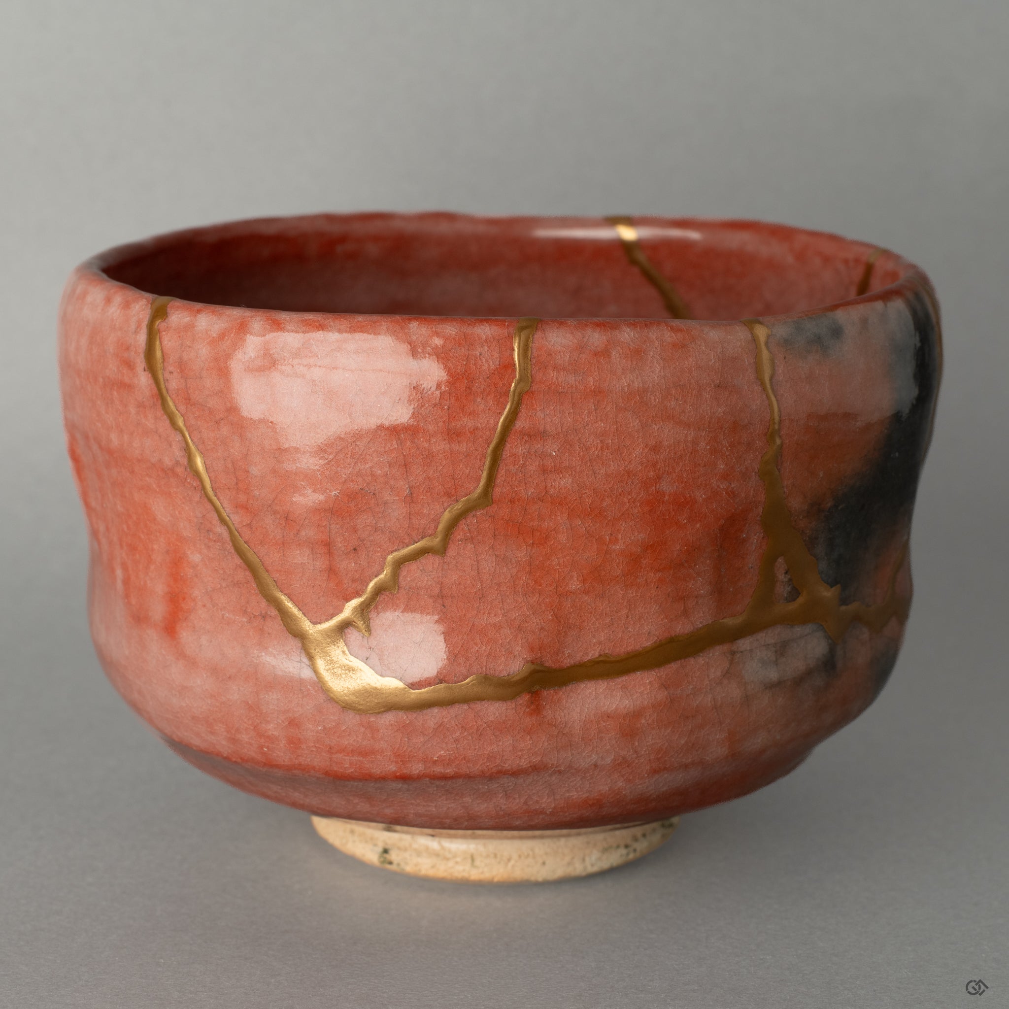 A close-up of the 24k gold kintsugi repair, revealing the tactile history of the bowl's second life, a story told in gold.