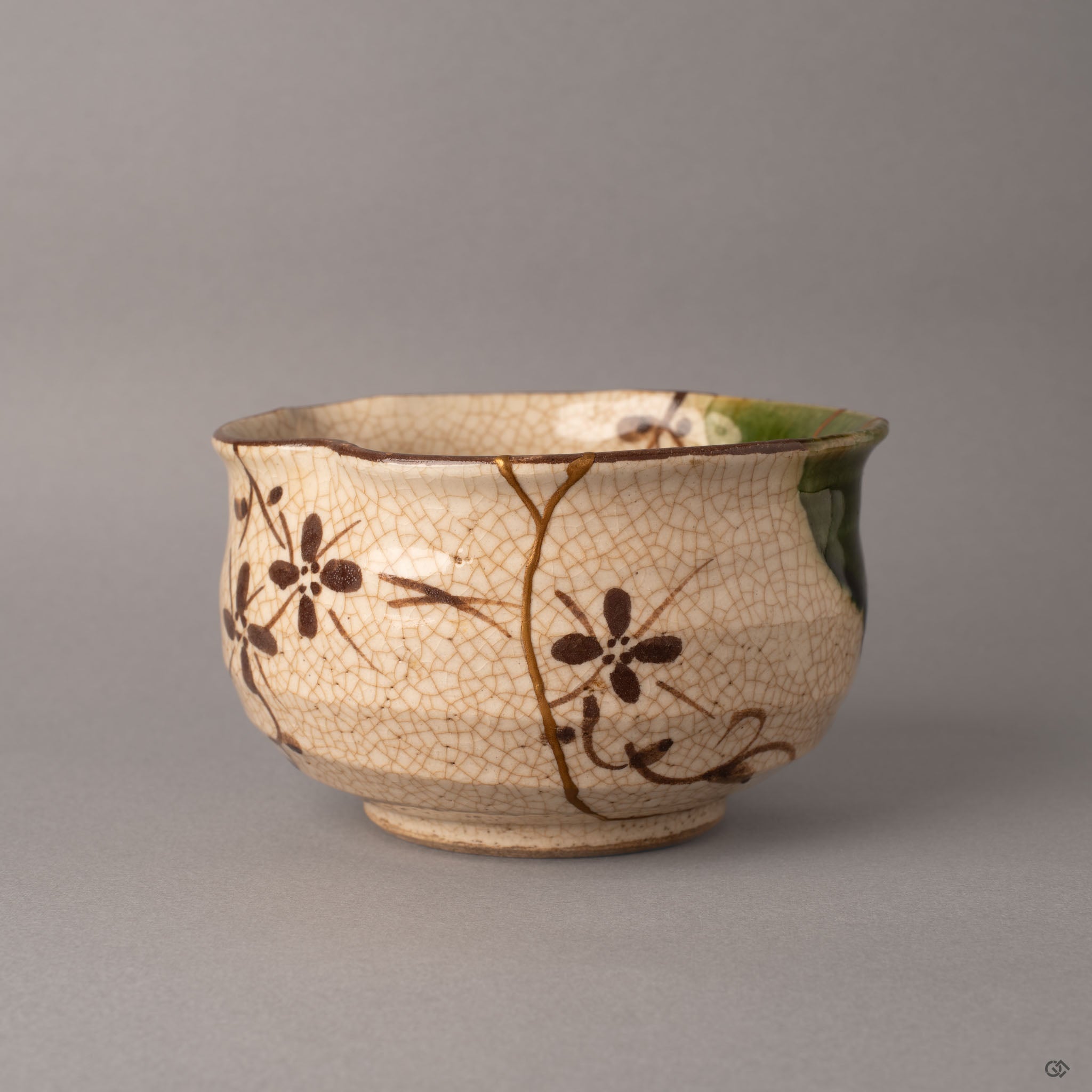 Side view of a kintsugi Oribe earthenware matcha bowl showing the robust hand-thrown form and gold seams over crackled glaze, heritage made visible.