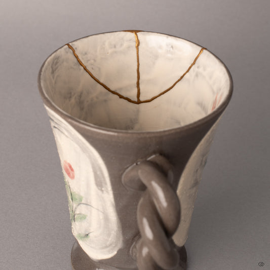 Gold kintsugi seams glow faintly against the mug's interior, each mended line a testament to crafted resilience.