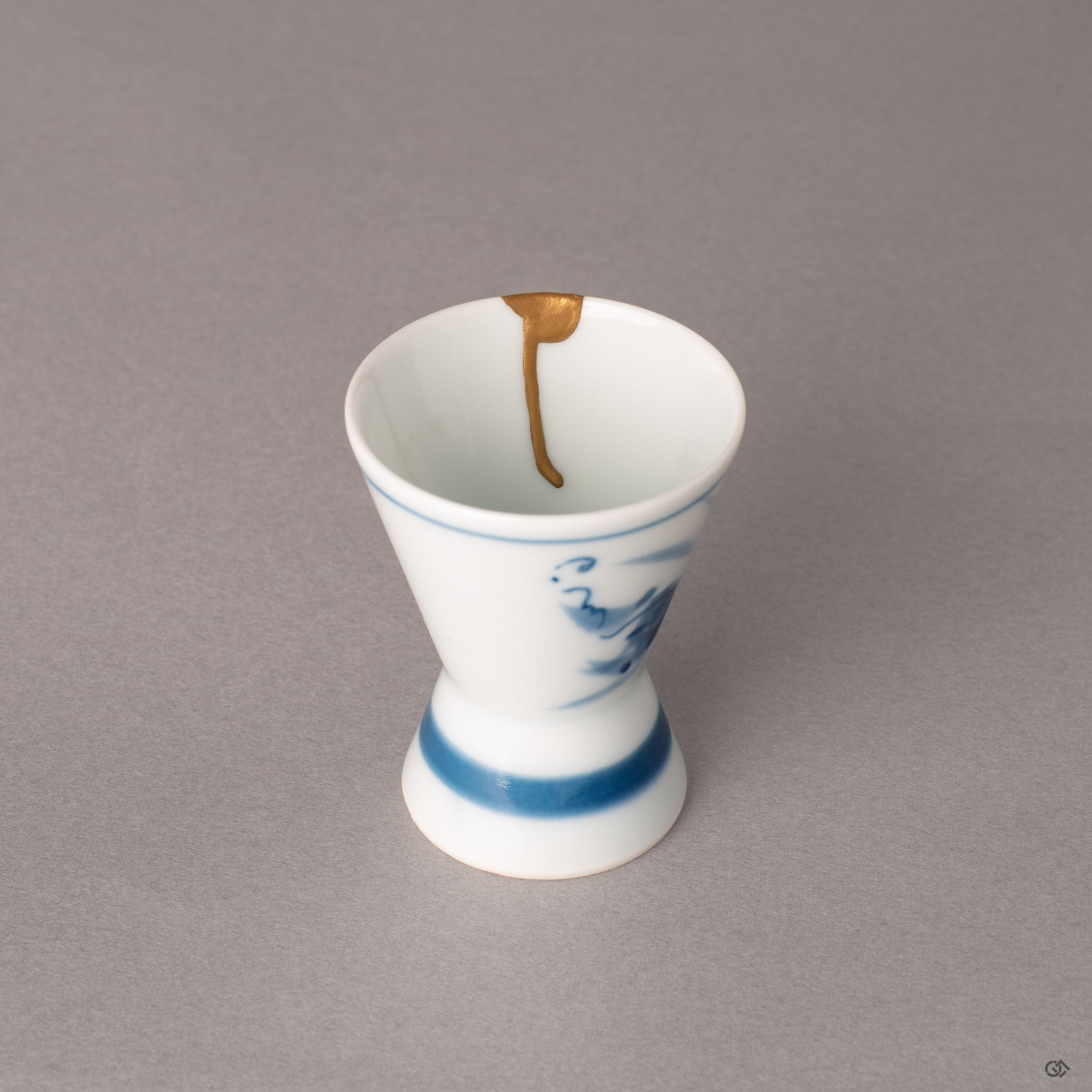 Interior of a kintsugi Ko-Imari sake cup showing roiro-polished gold seam meeting white porcelain, history made visible.