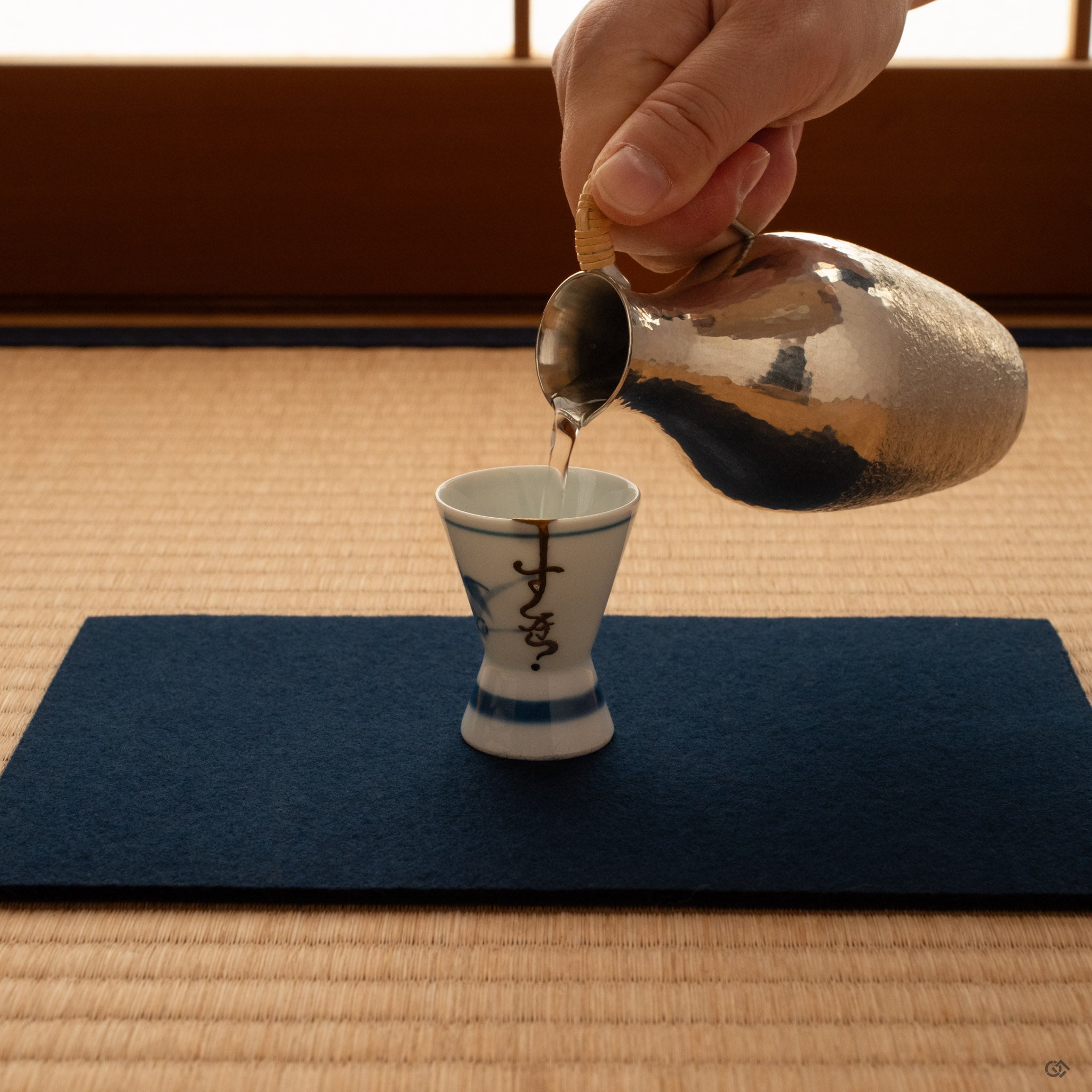 Kintsugi Ko-Imari sake cup on tatami in warm light, gold seam and eggshell inlay glowing, a moment of contemplation.